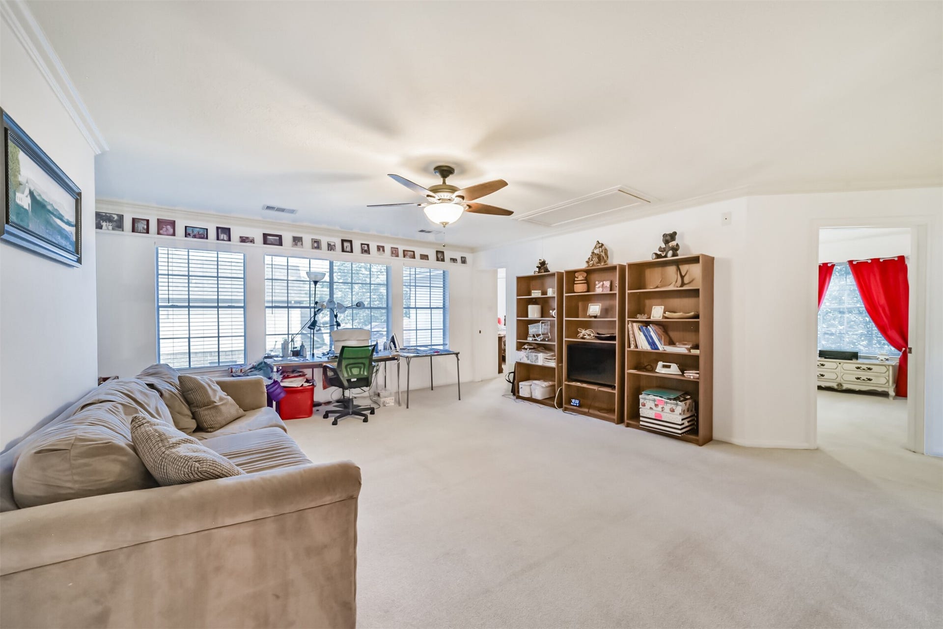 18402 Spinner Court Drive, Humble, TX 77346 Upstairs, the game room is bright and airy, with a wall of windows and a ceiling fan with a built-in light fixture.