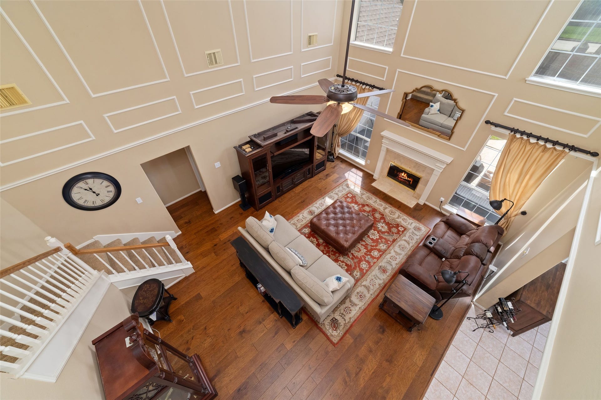 View from the second-floor overlook emphasizing the living rooms scale, tall windows, and open design.