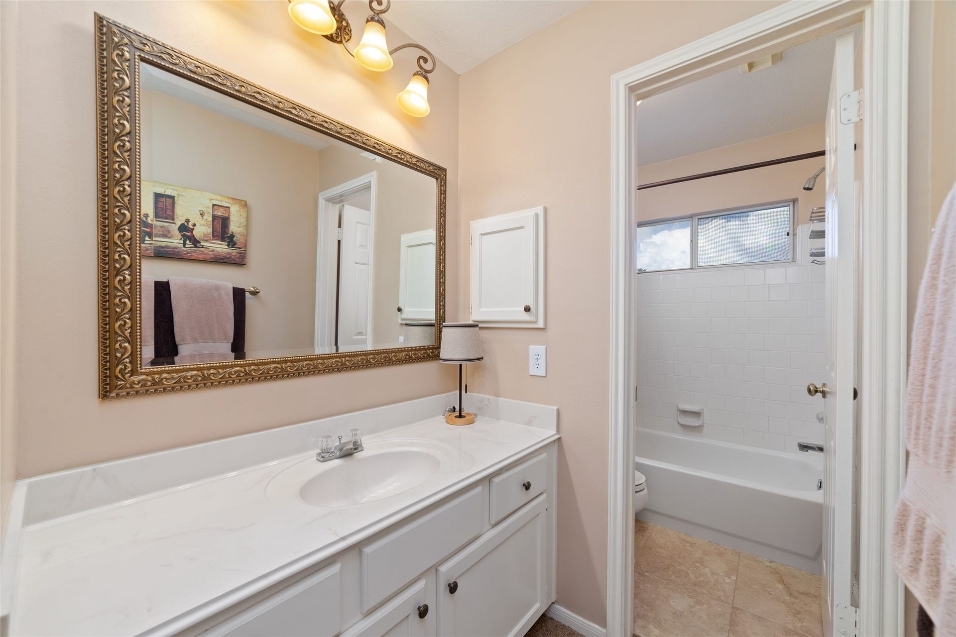 Secondary bathroom with an extended vanity and separate tub-and-shower area.