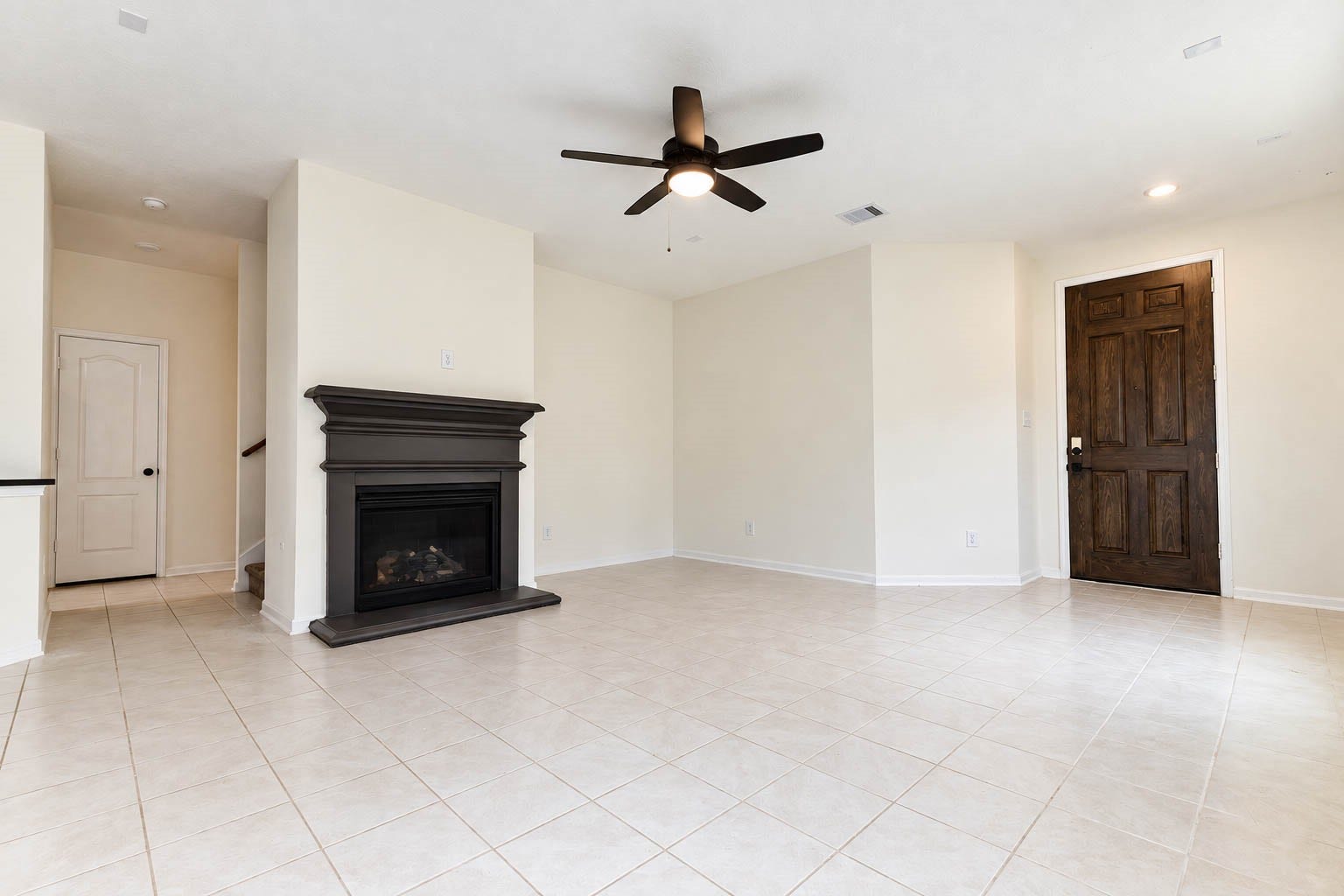 6131 Morning Fern Lane, Humble, TX 77338 The spacious open-concept family room exudes warmth & elegance, showcasing beautiful tile flooring, soaring ceilings, recessed lighting, & a stylish ceiling fan. A soothing neutral color palette enhances the bright, airy atmosphere while providing a timeless backdrop to complement any decorating style.