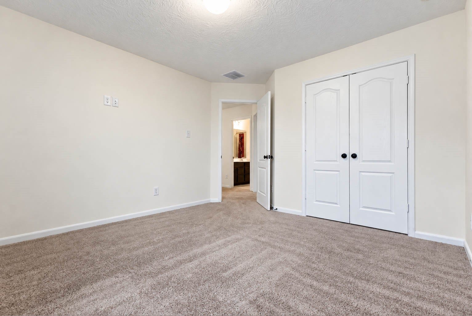 6131 Morning Fern Lane, Humble, TX 77338 Another view of this spacious secondary bedroom highlights its generous floor space, double-door closet, & soothing neutral color palette. The versatile layout offers endless possibilities for furniture arrangements, allowing you to personalize the space to suit your needs.