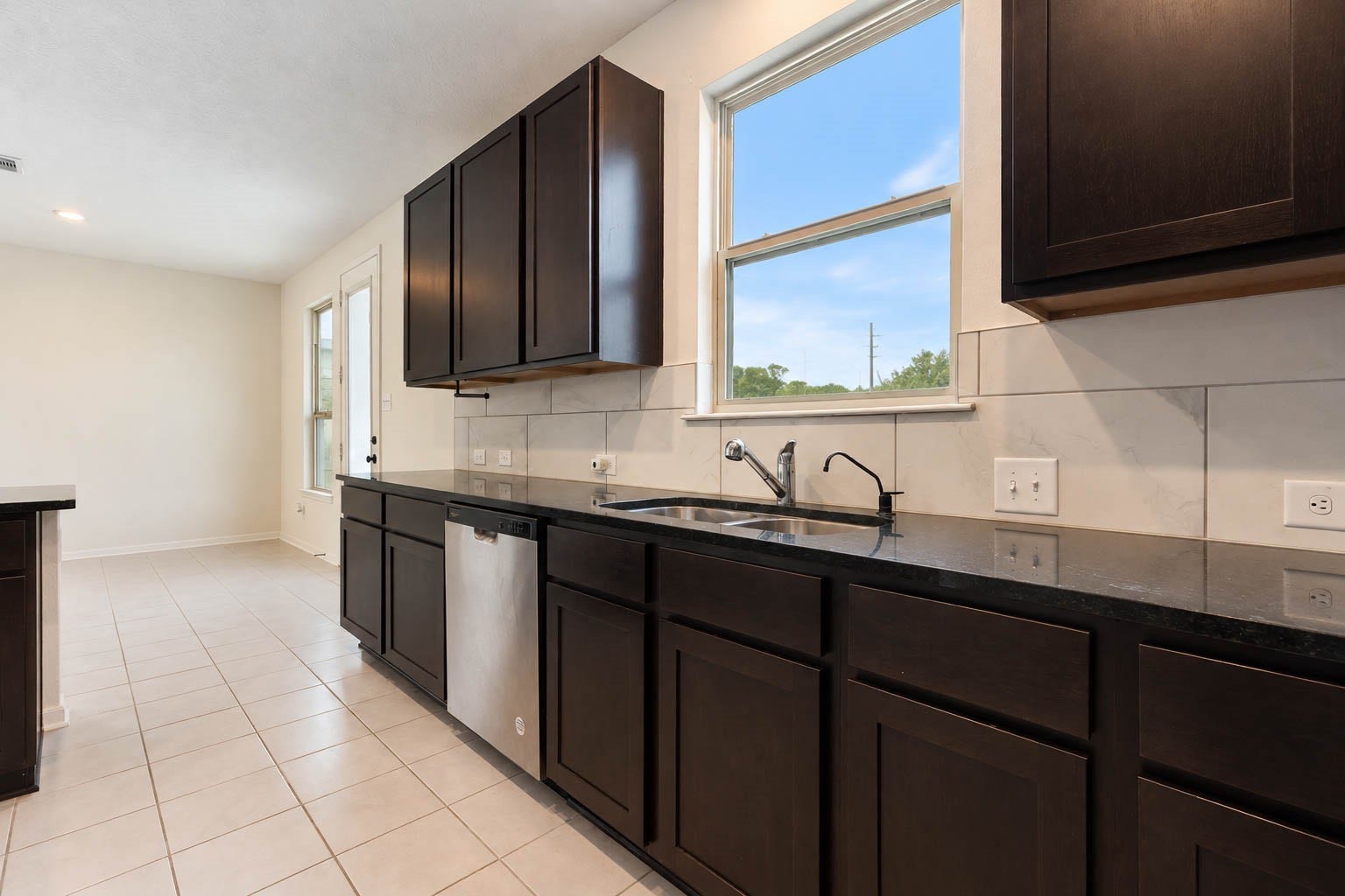 6131 Morning Fern Lane, Humble, TX 77338 Recessed lighting & a large window above the double-basin sink fill the kitchen with natural light, while the thoughtfully designed layout flows effortlessly into the adjoining dining area, with convenient access to the backyard & covered patio.