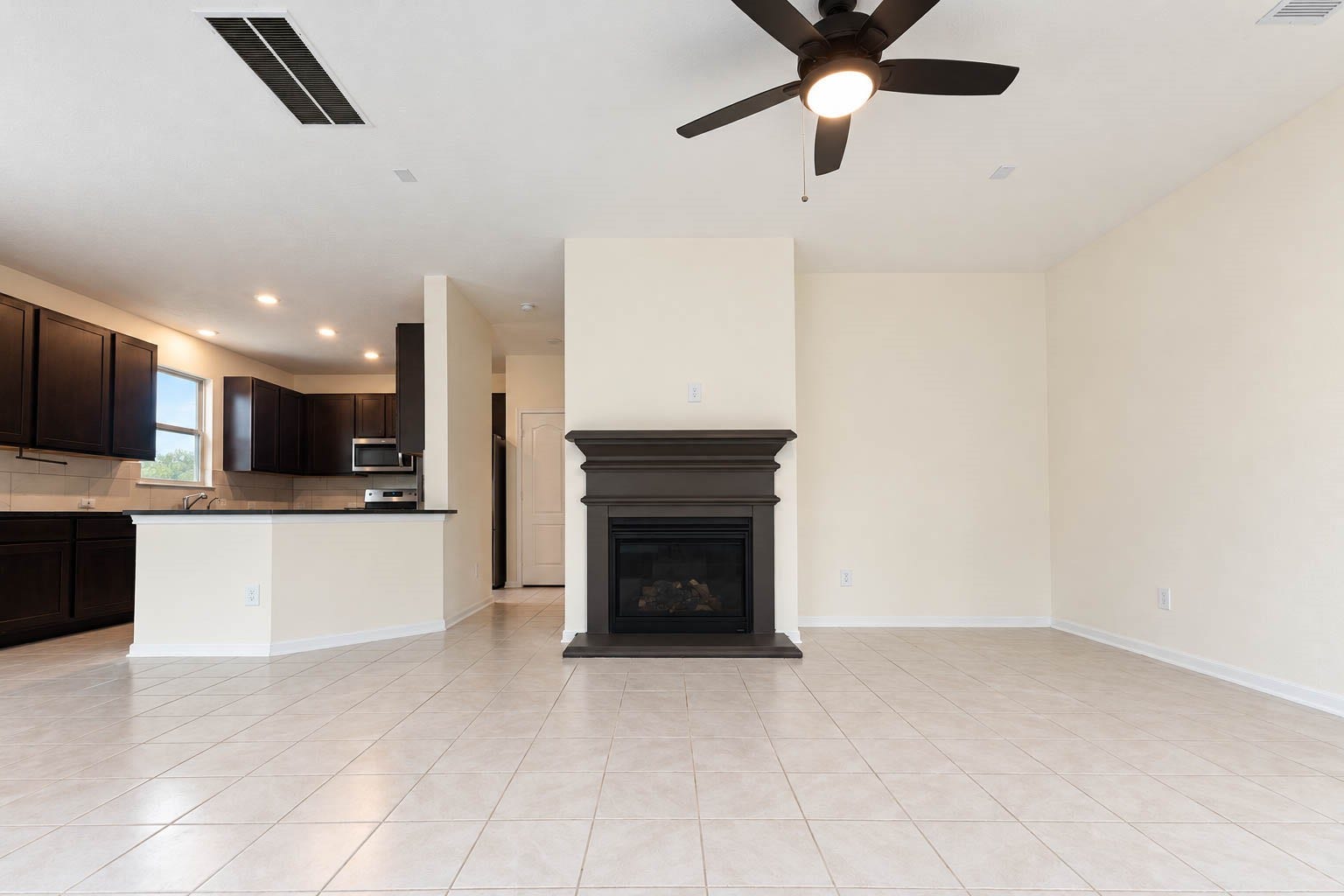 6131 Morning Fern Lane, Humble, TX 77338 A beautiful gas-log fireplace with a rich, dark mantel creates a stunning focal point, bringing warmth, timeless charm, & an inviting ambiance to the spacious family room.