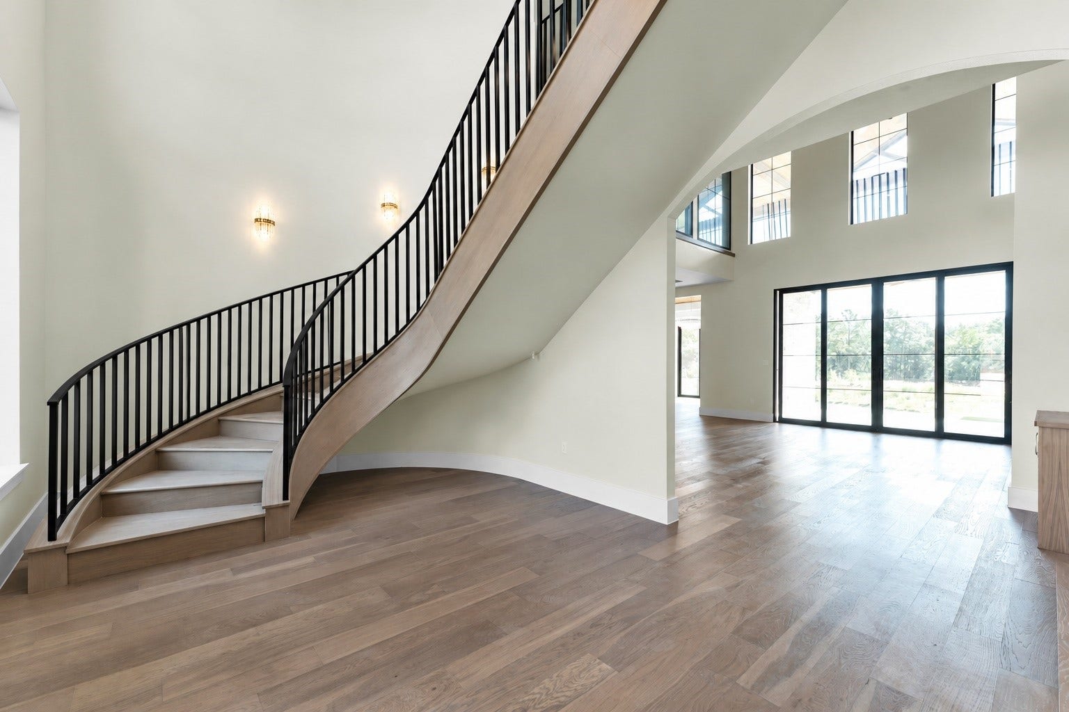 23701 Birch Grove Road, Montgomery, TX 77316 A breathtaking staircase elegantly sweeps upward, enhancing the home's grand entrance with its stunning, modern design. *The bottom railings still in the works*