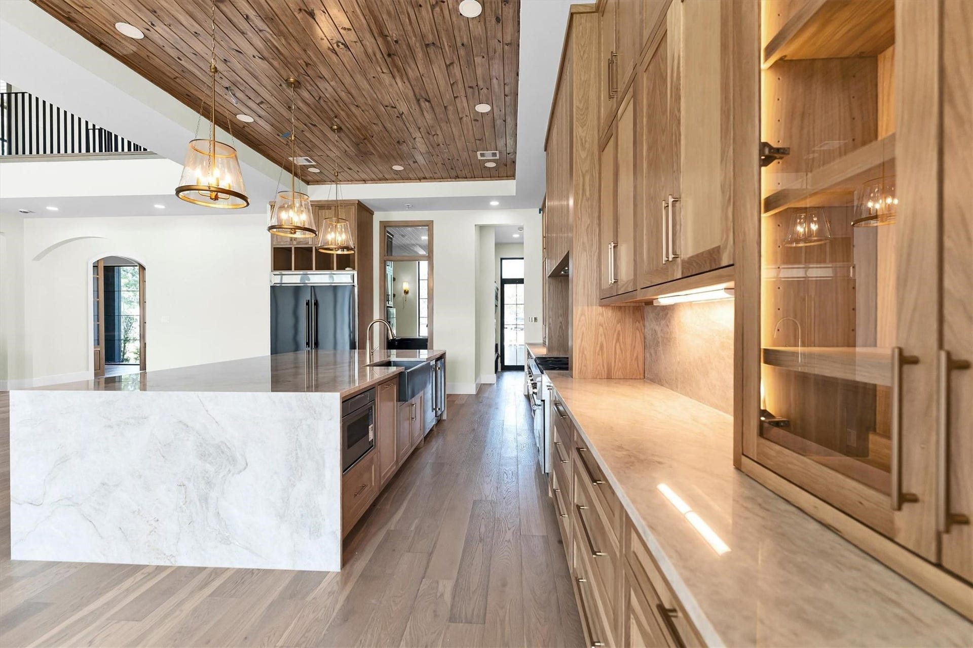 23701 Birch Grove Road, Montgomery, TX 77316 Experience modern elegance in this stunning kitchen, featuring warm wood cabinetry with sleek under-cabinet lighting that beautifully illuminates the expansive countertops.