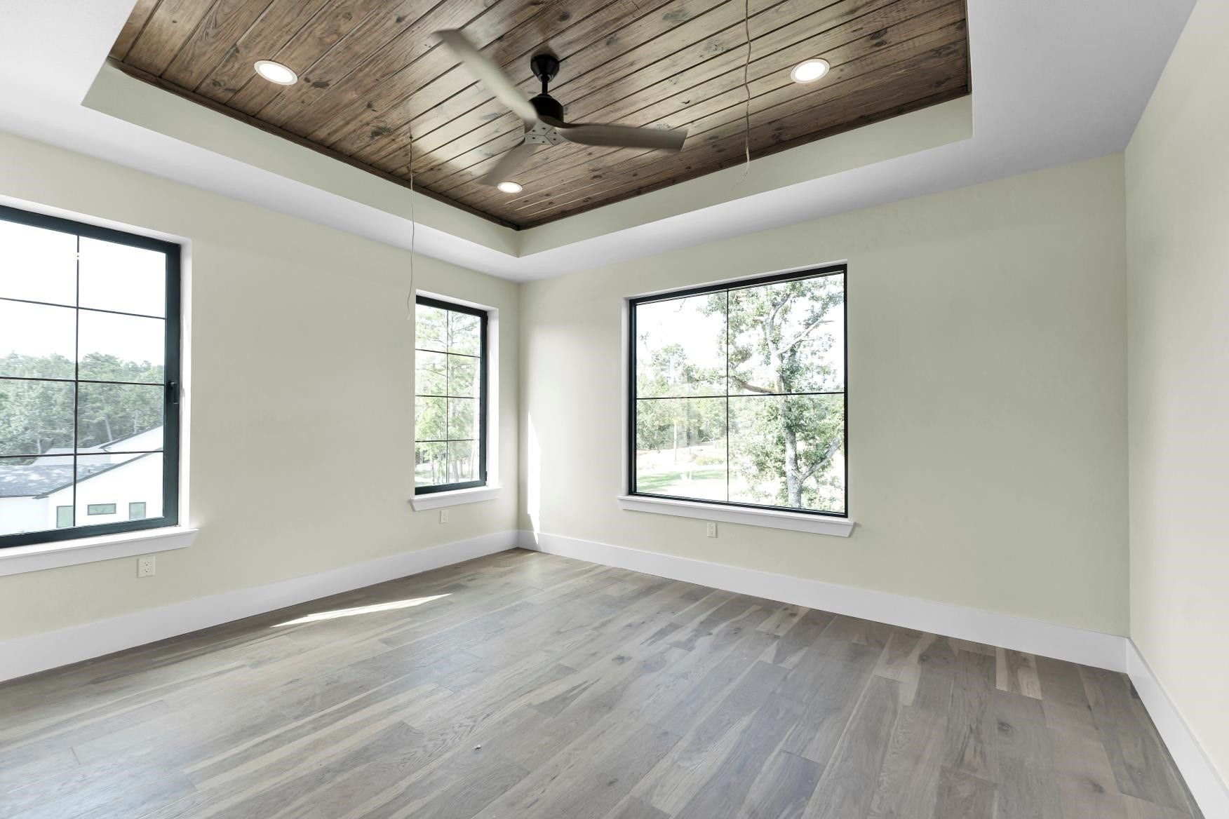 23701 Birch Grove Road, Montgomery, TX 77316 Discover the third bedroom's charm with its stunning wood-paneled ceiling, abundant natural light, and serene views, creating a perfect retreat for relaxation.