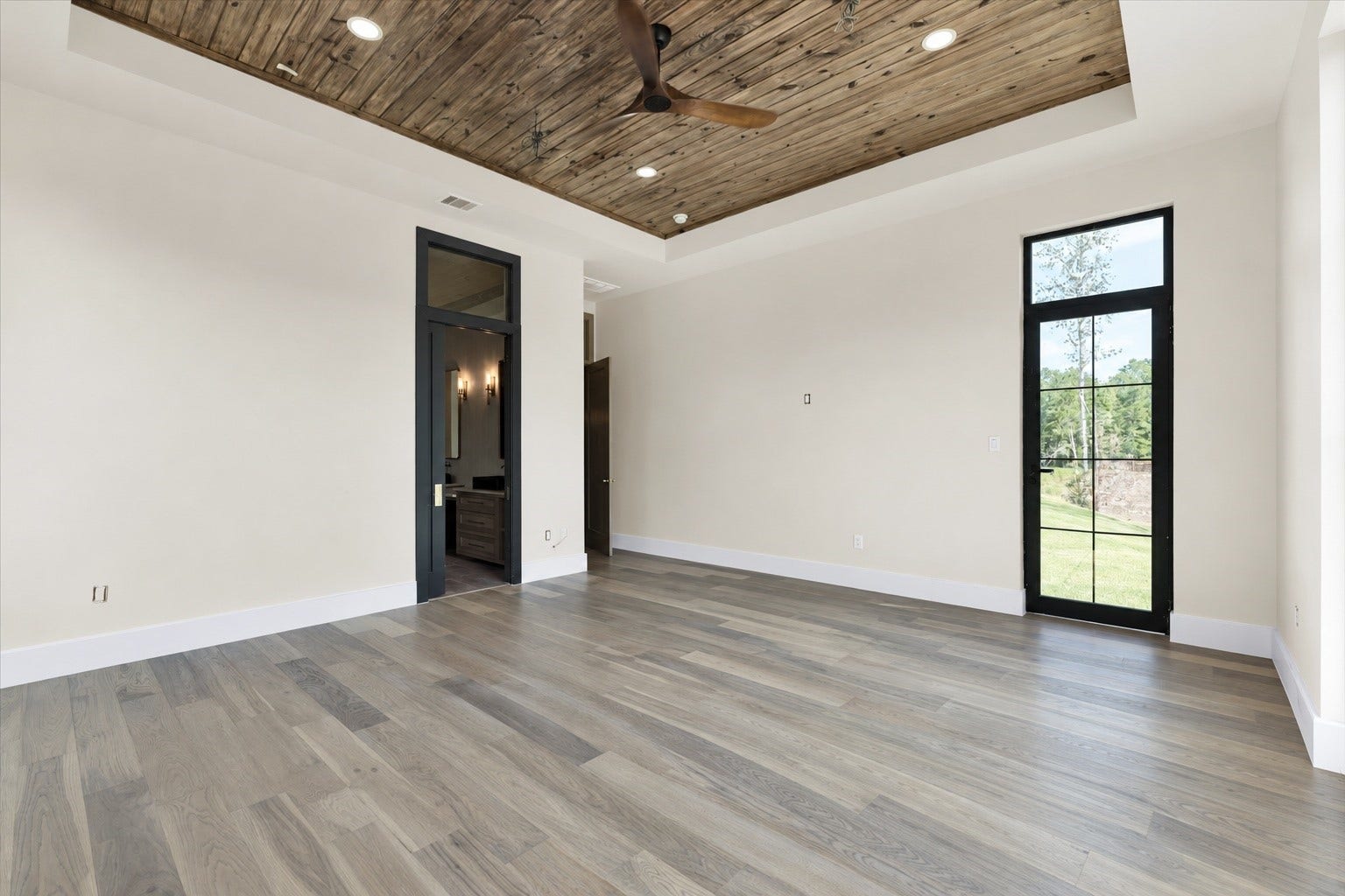 23701 Birch Grove Road, Montgomery, TX 77316 Experience serene elegance in the main bedroom, featuring a stunning picture window that invites an abundance of natural light and offers picturesque views.