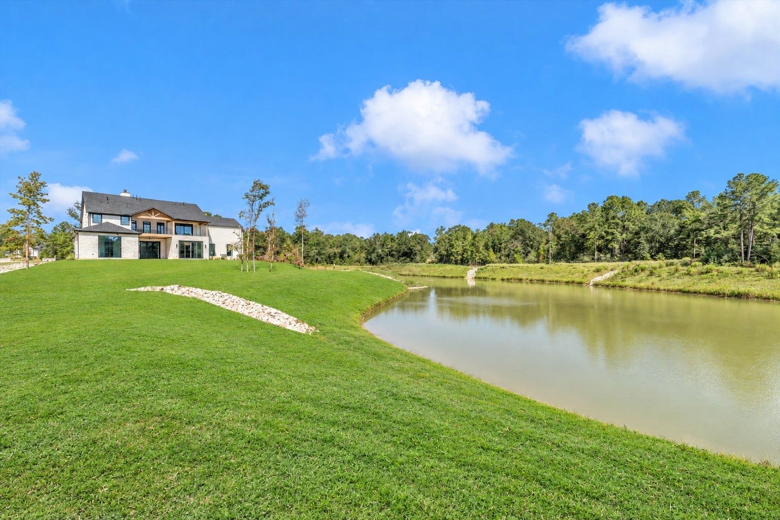 23701 Birch Grove Road, Montgomery, TX 77316 Stunning home nestled on lush, expansive grounds with a serene pond, offering picturesque views and tranquil living.
