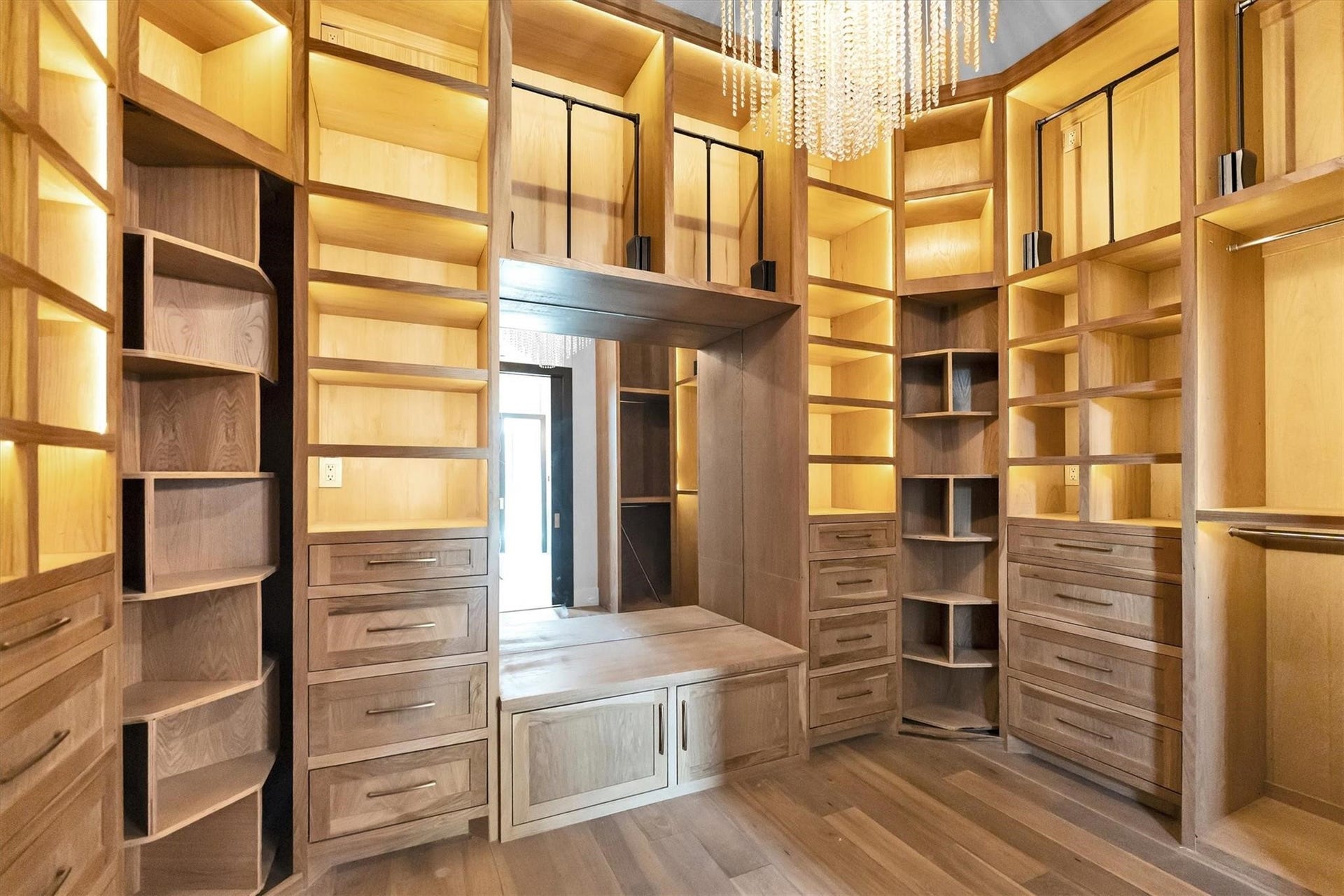 23701 Birch Grove Road, Montgomery, TX 77316 Luxurious walk-in closet featuring custom wood cabinetry, abundant shelving, and elegant lighting for a sophisticated storage solution.