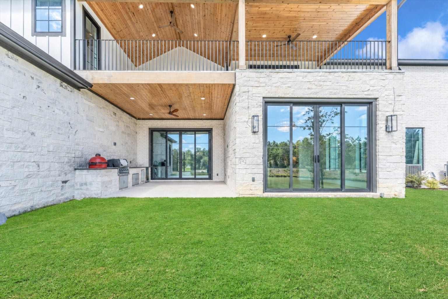 23701 Birch Grove Road, Montgomery, TX 77316 Discover the perfect blend of luxury and relaxation with this stunning property's expansive patio, complete with a built-in grill and lush green views.