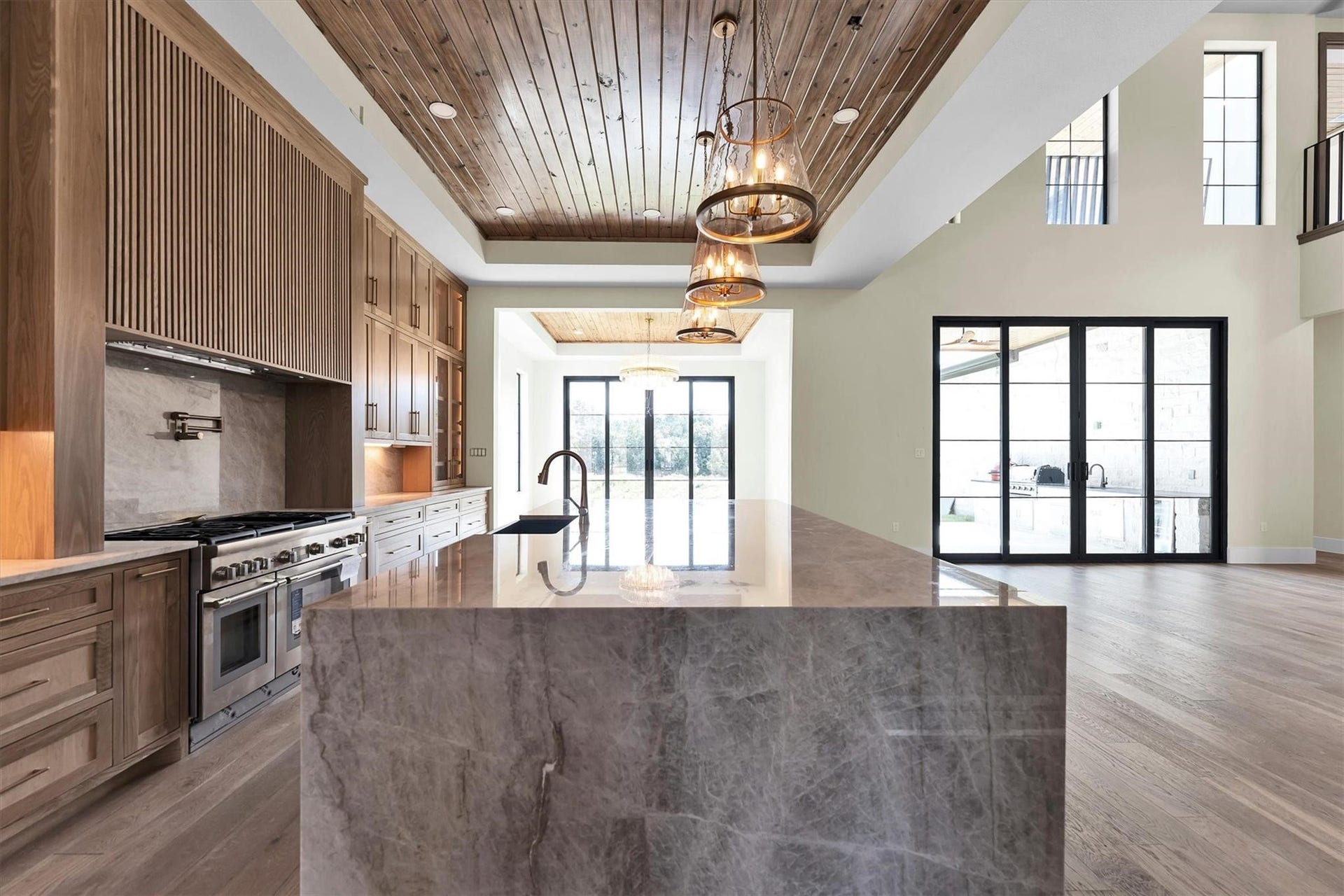 23701 Birch Grove Road, Montgomery, TX 77316 Experience culinary luxury in this stunning kitchen, featuring top-of-the-line Thermador appliances, exquisite wooden cabinetry, and elegant marble countertops, all under a beautifully crafted wood-paneled ceiling.