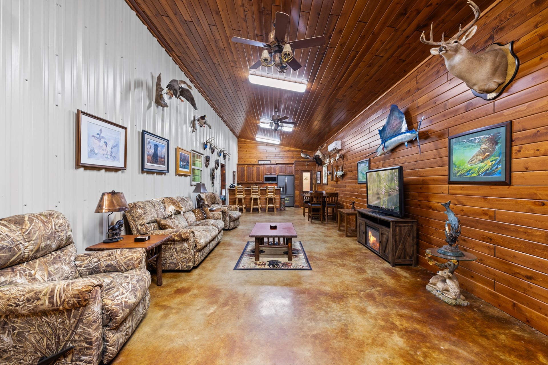 An entertainers dream! This impressive man cave and gathering space features beautiful wood walls and ceilings, stained concrete floors, a spacious living area, and a kitchen with bar seating. The perfect setting for hosting family and friends or simply relaxing!