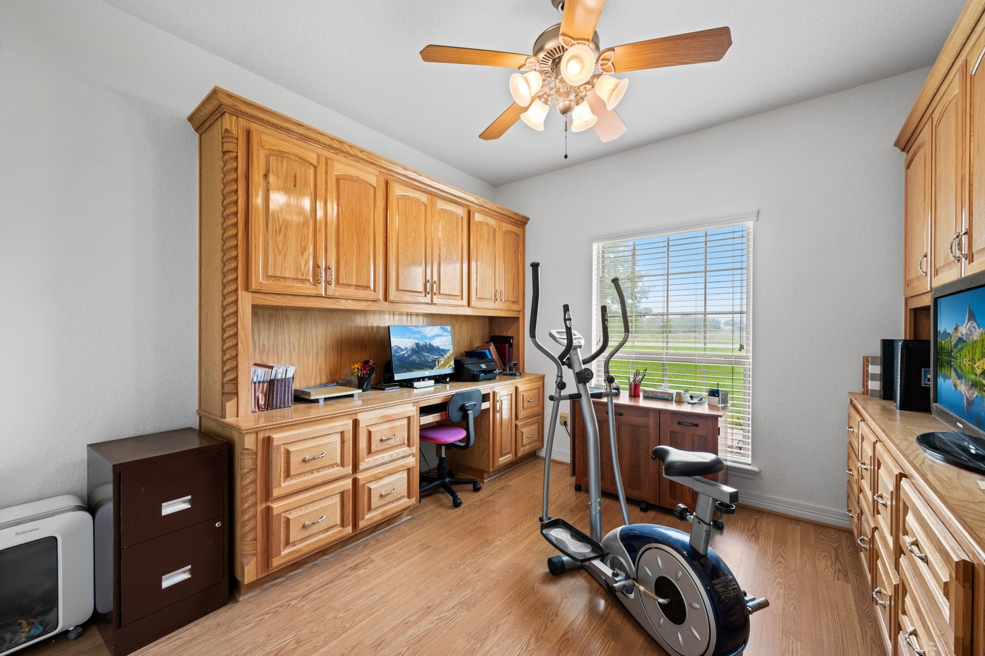 Dedicated home office featuring beautiful custom wood cabinetry, built-in desk, abundant storage, and plenty of natural light.