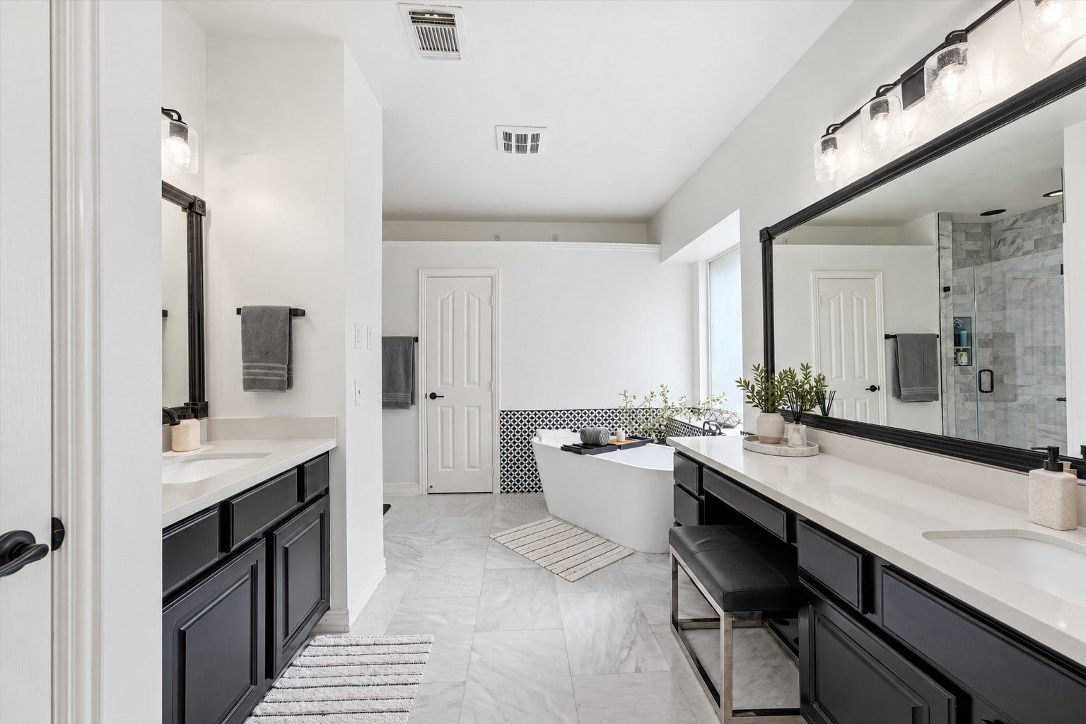 Updated primary bathroom with double vanities.  This photo has been lightly digitally staged.