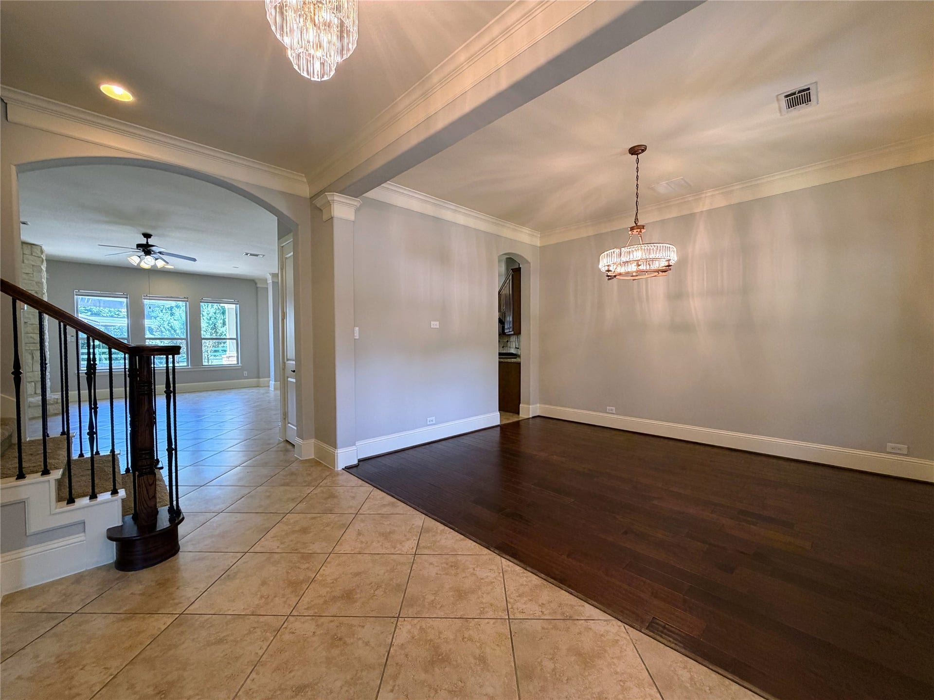 5119 Water Oak Crescent, Fulshear, TX 77441 Elegant formal dining space! Showcases rich hardwood flooring, detailed crown molding, and a statement chandelier. Connects seamlessly to the tiled entryway, sweeping staircase, and the open living area beyond.