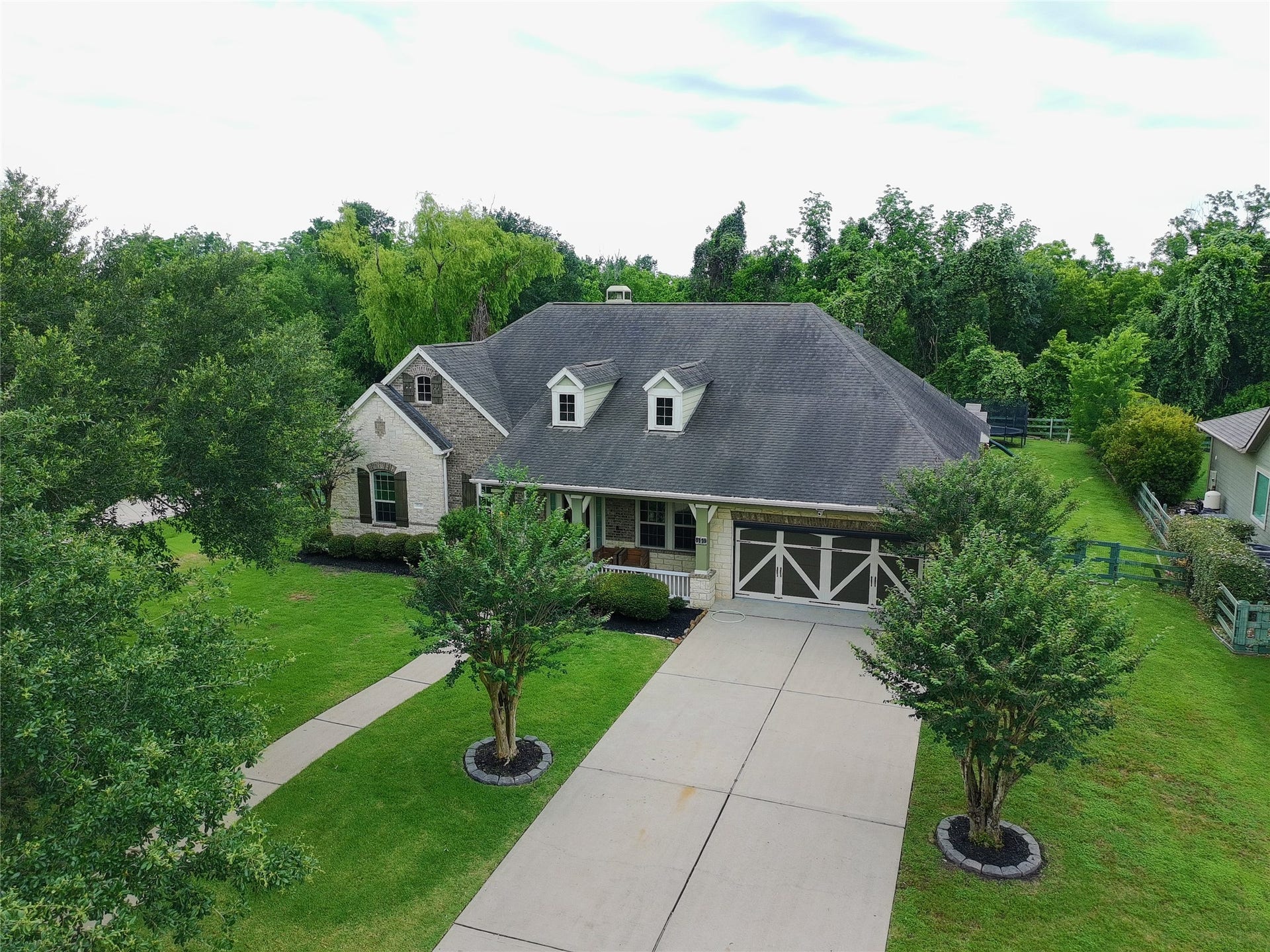 5119 Water Oak Crescent, Fulshear, TX 77441 Stunning, private Fulshear retreat! Features a spacious driveway, pristine landscaping, classic stone accents, and a gorgeous wooded backdrop.
