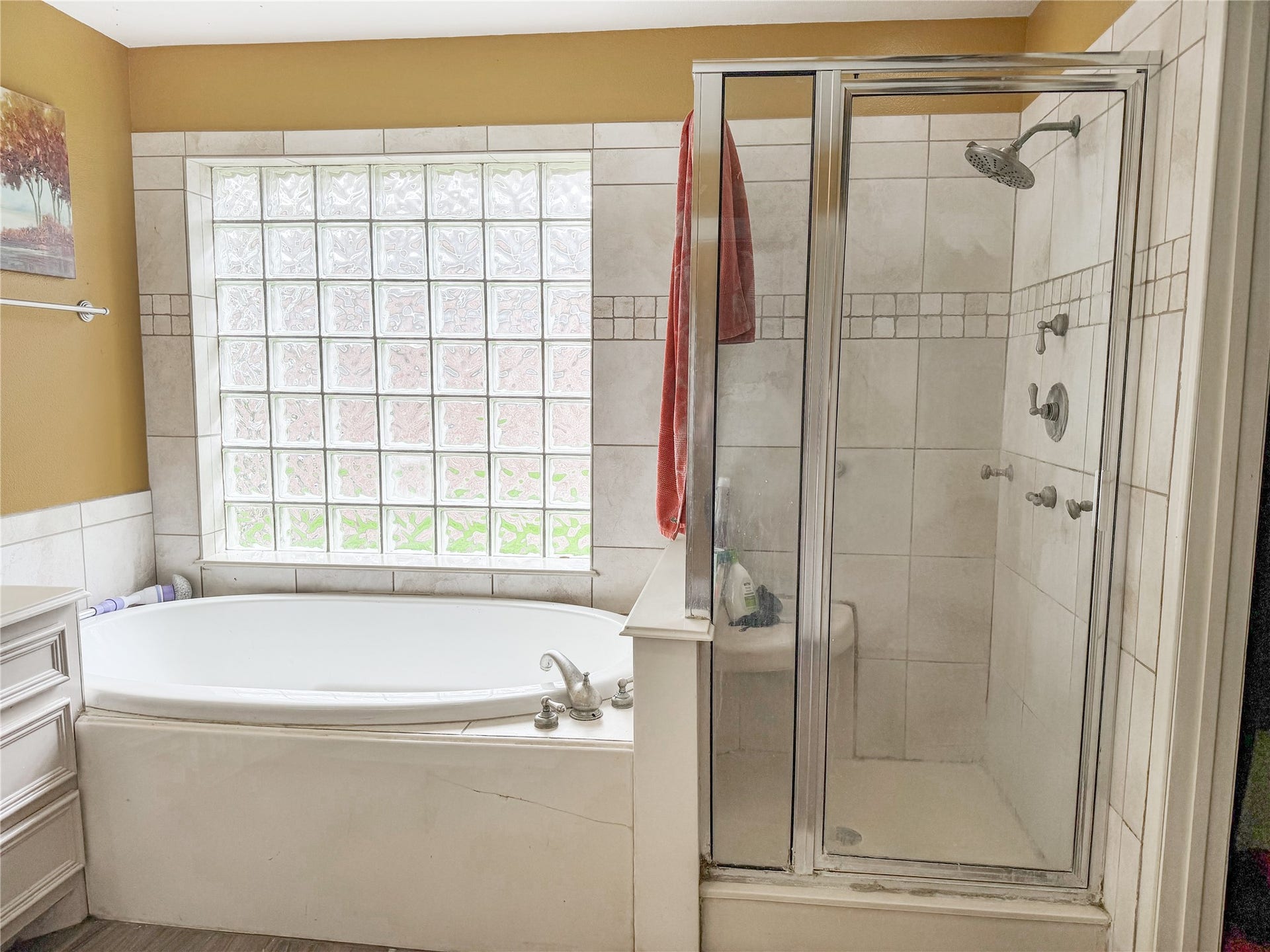 134 Dove Trail, Richwood, TX 77531 Primary bathroom featuring a separate stand-up shower and soaking tub, offering both convenience and a relaxing place to unwind.