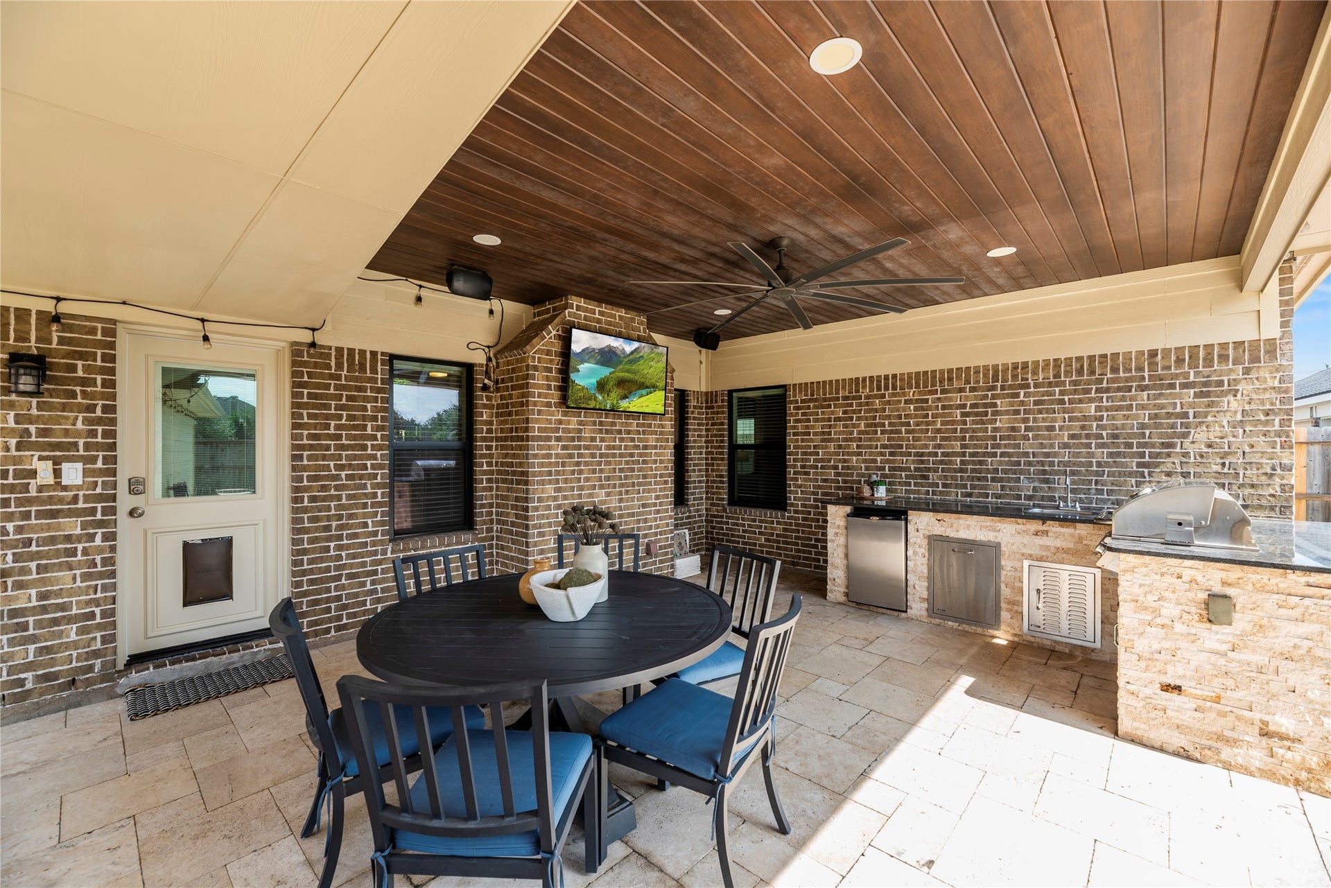 26819 Rockwood Park Lane, Cypress, TX 77433 Large covered patio area with a ceiling fan and an outdoor kitchen overlooking the pool.