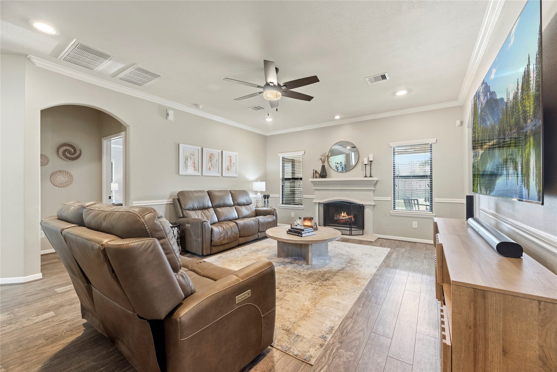 26819 Rockwood Park Lane, Cypress, TX 77433 Family room offers wood-look tile flooring, crown molding, ceiling fan, cozy fireplace and great backyard views.