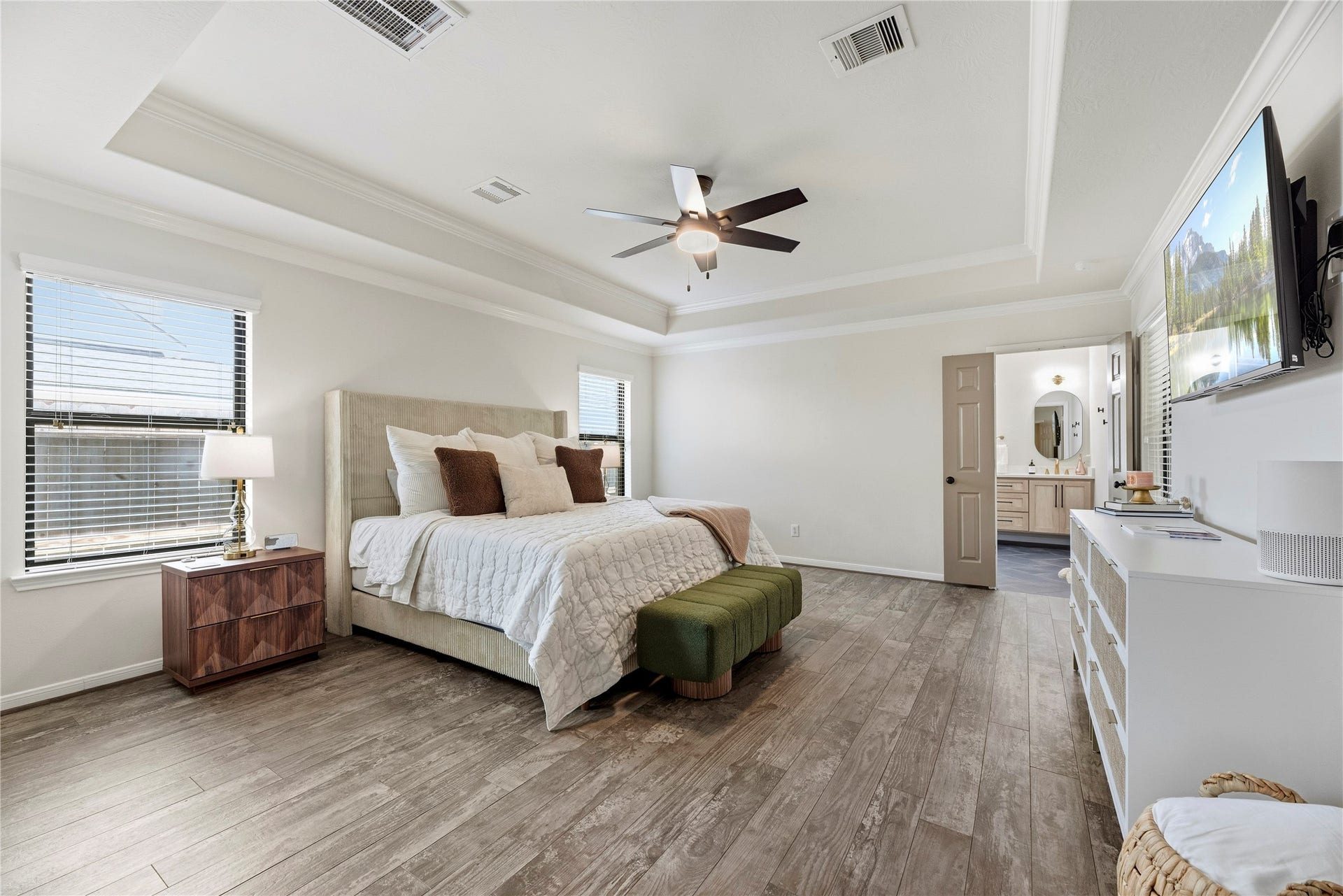 26819 Rockwood Park Lane, Cypress, TX 77433 Spacious primary retreat boasts wood-look tile flooring, tray ceiling, crown molding, walk-in closet and an en-suite bathroom.