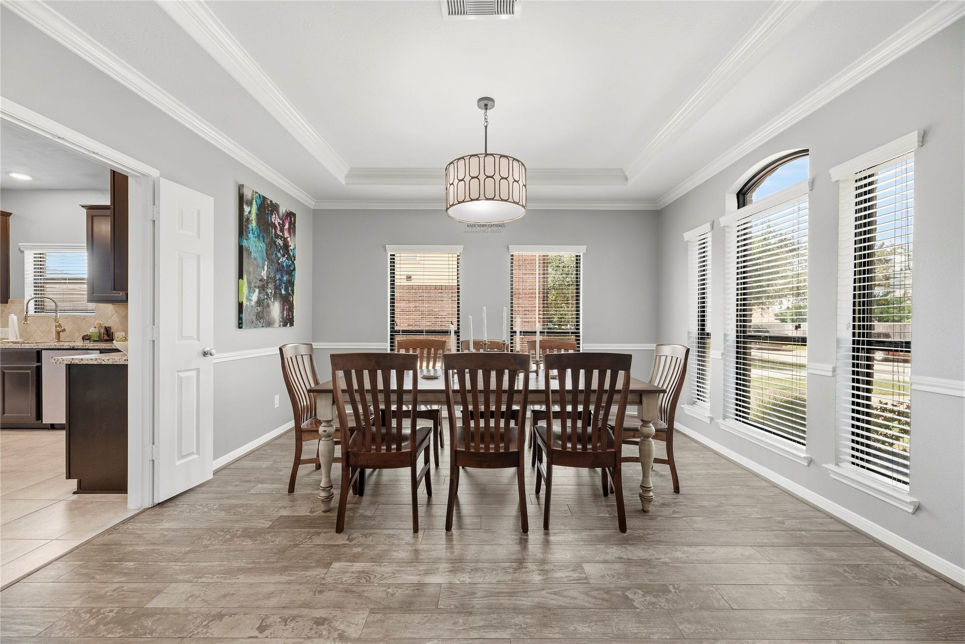 26819 Rockwood Park Lane, Cypress, TX 77433 Elegant formal dining room with a tray ceiling, crown molding, chair rail and modern light fixture.