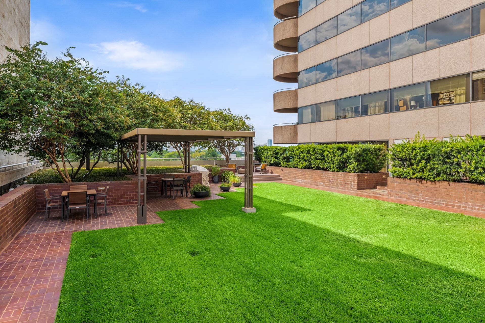 A manicured lawn and shaded gathering areas form part of the sixth-floor recreational amenities. This inviting green space adds a refreshing open-air dimension to high-rise living.