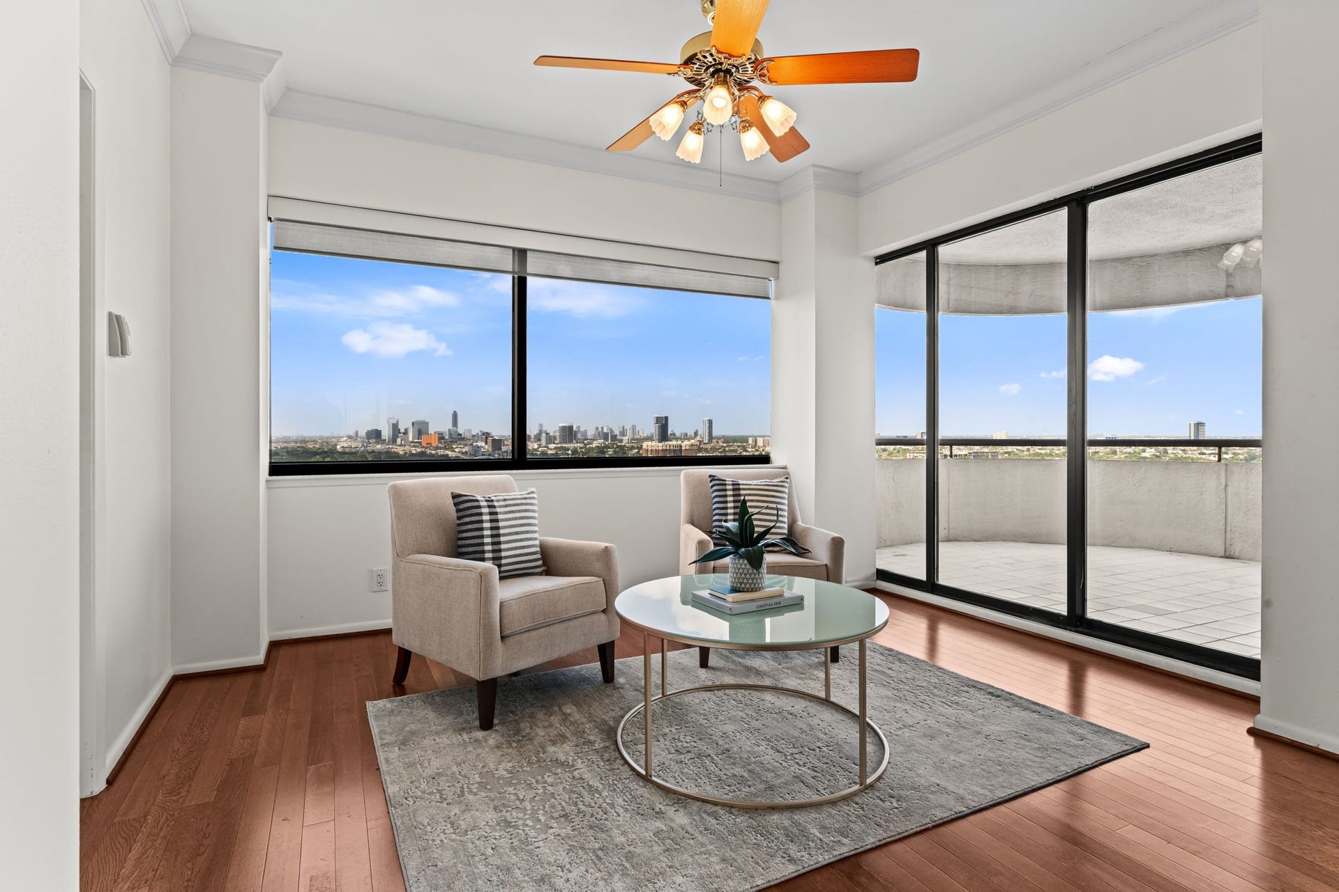 Corner windows create an airy setting with far-reaching views across Houston. The room's balanced proportions accommodate both formal gatherings and relaxed daily living.