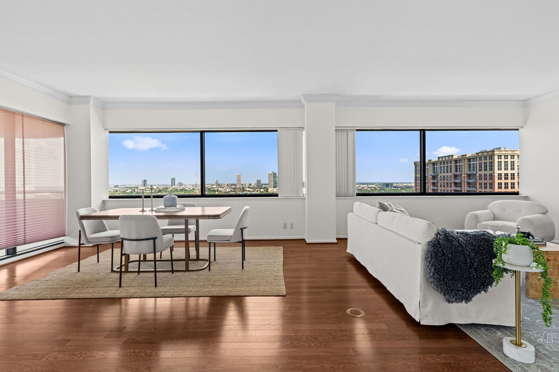 The main living area is framed by broad windows that capture abundant daylight and elevated city views. Hardwood flooring and an open arrangement create a polished setting for everyday living and entertaining.