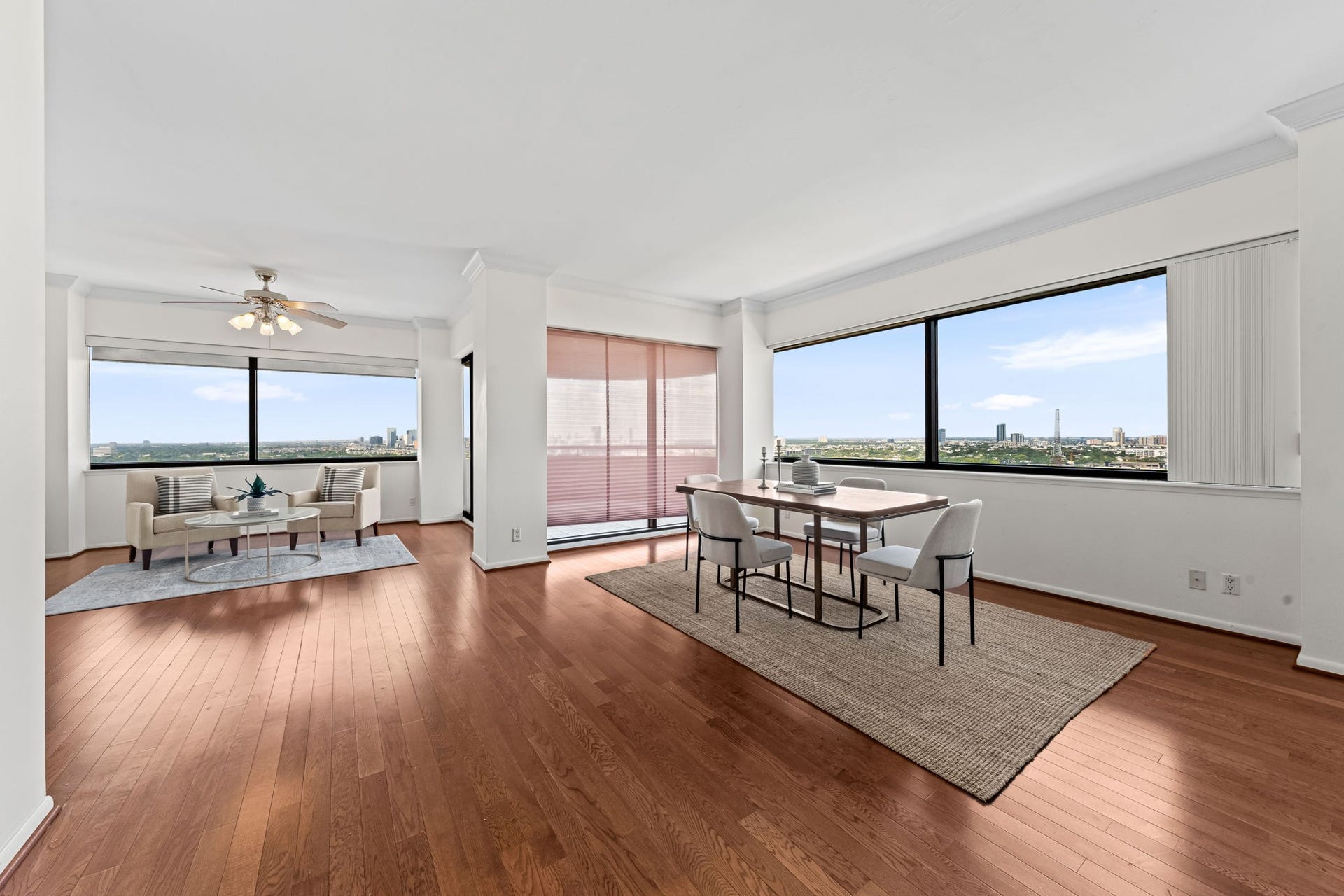 The open living and dining areas flow together across beautiful hardwood floors. Floor-to-ceiling views lend a dramatic backdrop to gatherings both intimate and grand. Spacious living & dining areas create an inviting setting for intimate gatherings or larger occasions.