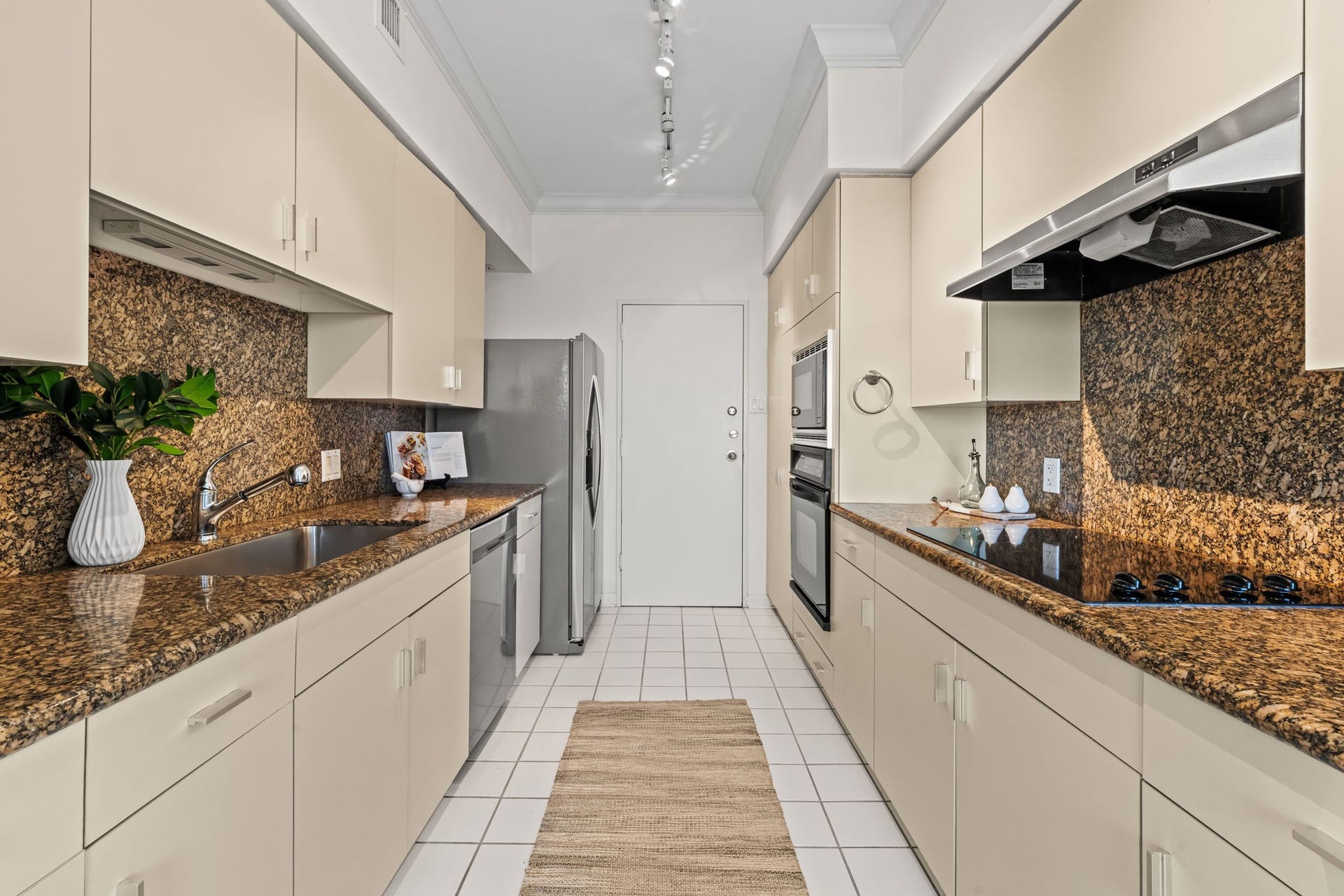 The kitchen provides extensive cabinetry, generous preparation surfaces, and an efficient galley configuration. Its practical layout supports both daily meals and larger-scale entertaining.
