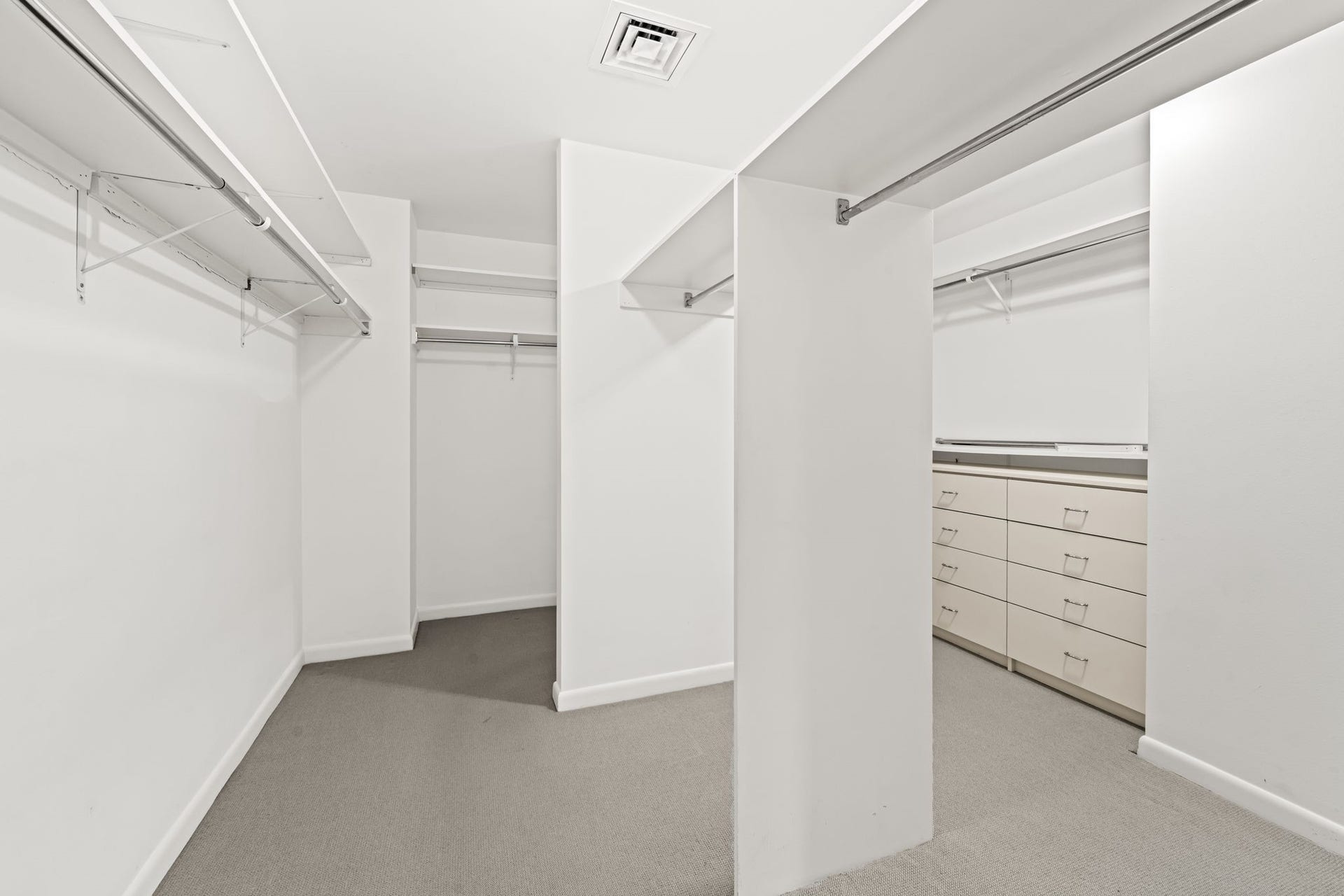 An oversized walk-in closet provides extensive shelving and hanging space. The thoughtful configuration offers exceptional storage and organization within the residence.