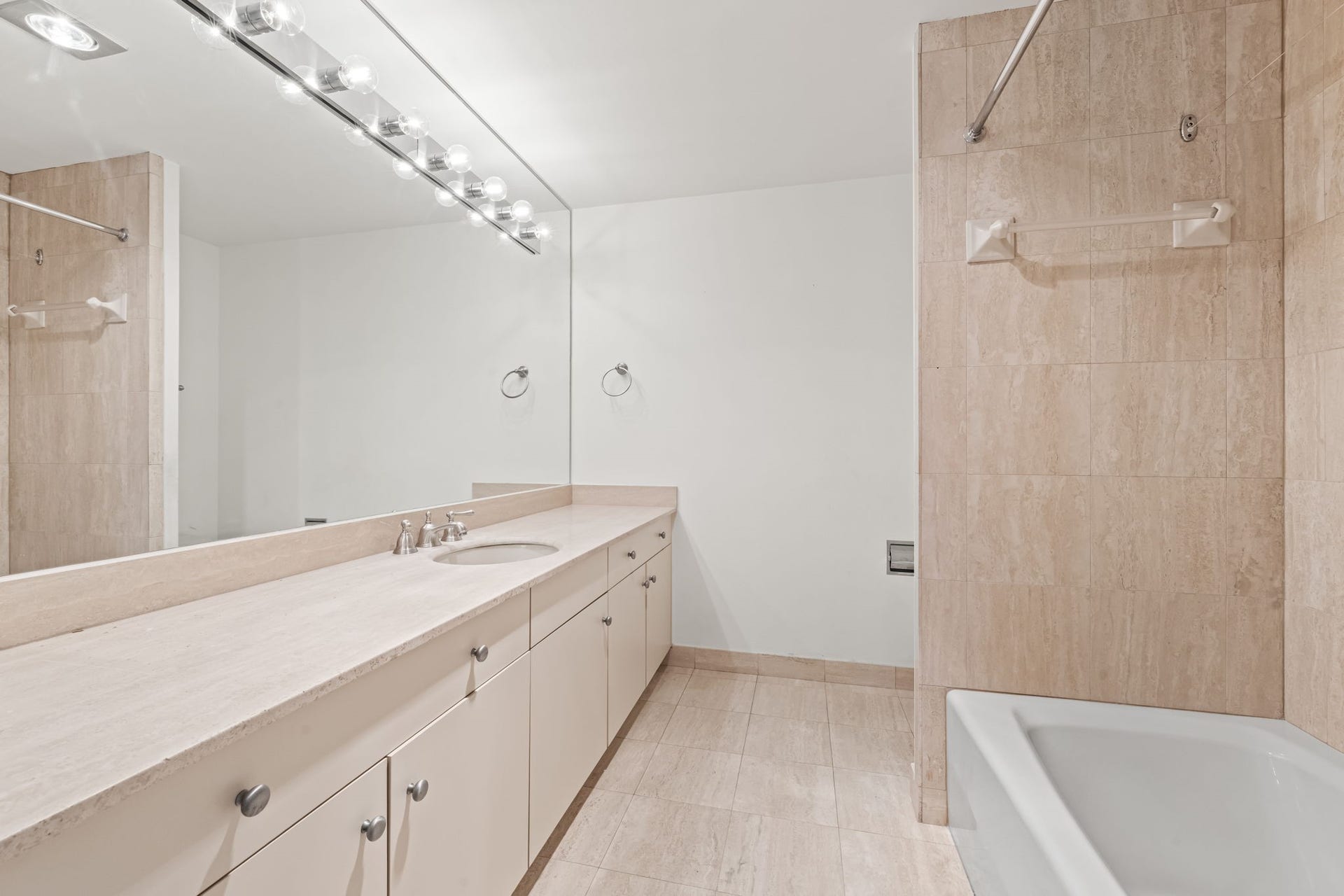 A broad vanity and coordinated finishes give this bathroom a bright, composed appearance. Ample counter space and storage support everyday routines with ease.