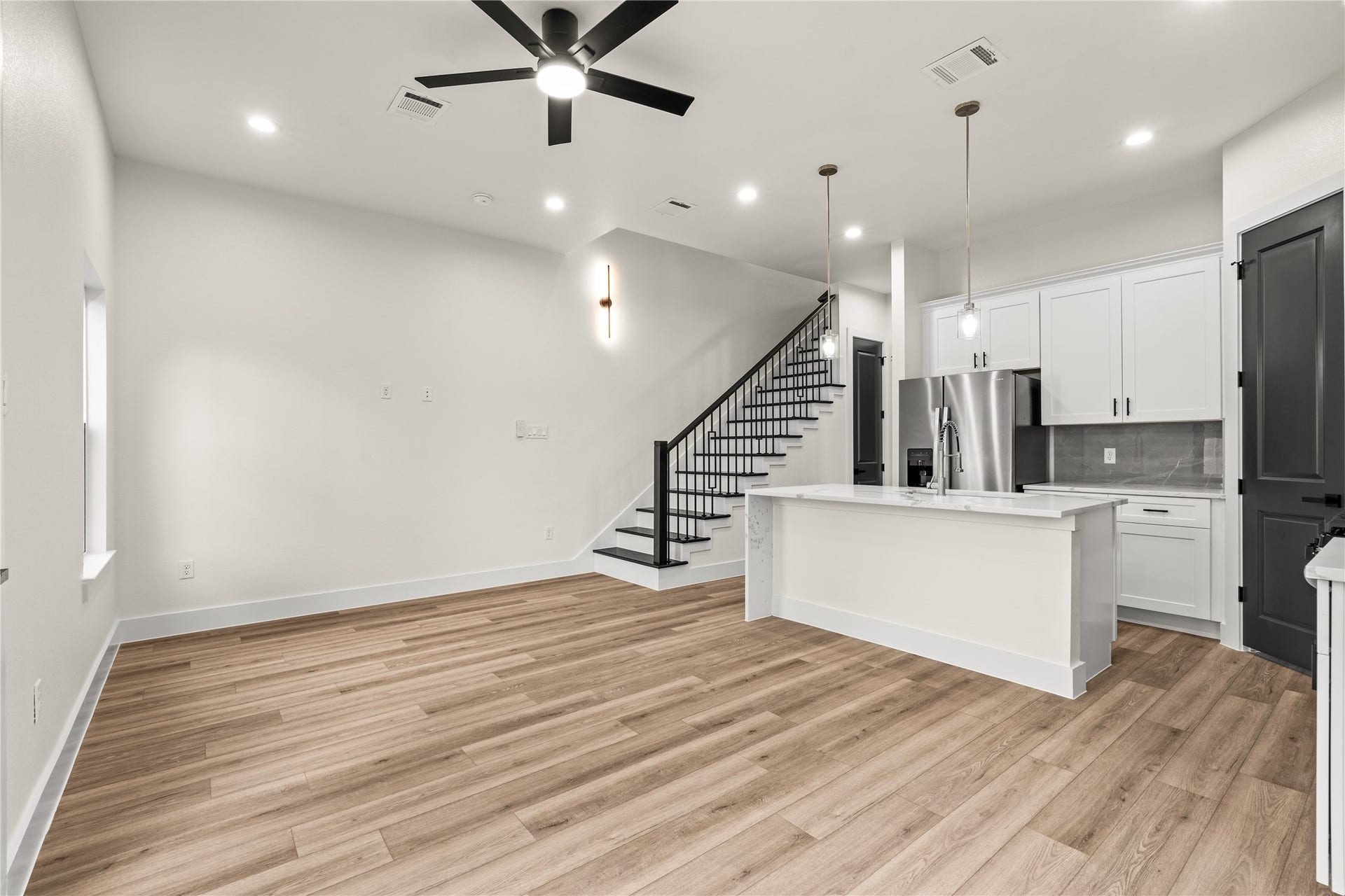 4521 Newberry Street, Houston, TX 77051 Expansive open living room sleek ceiling fan, continuous wood-look flooring, and direct sightlines to the kitchen island.