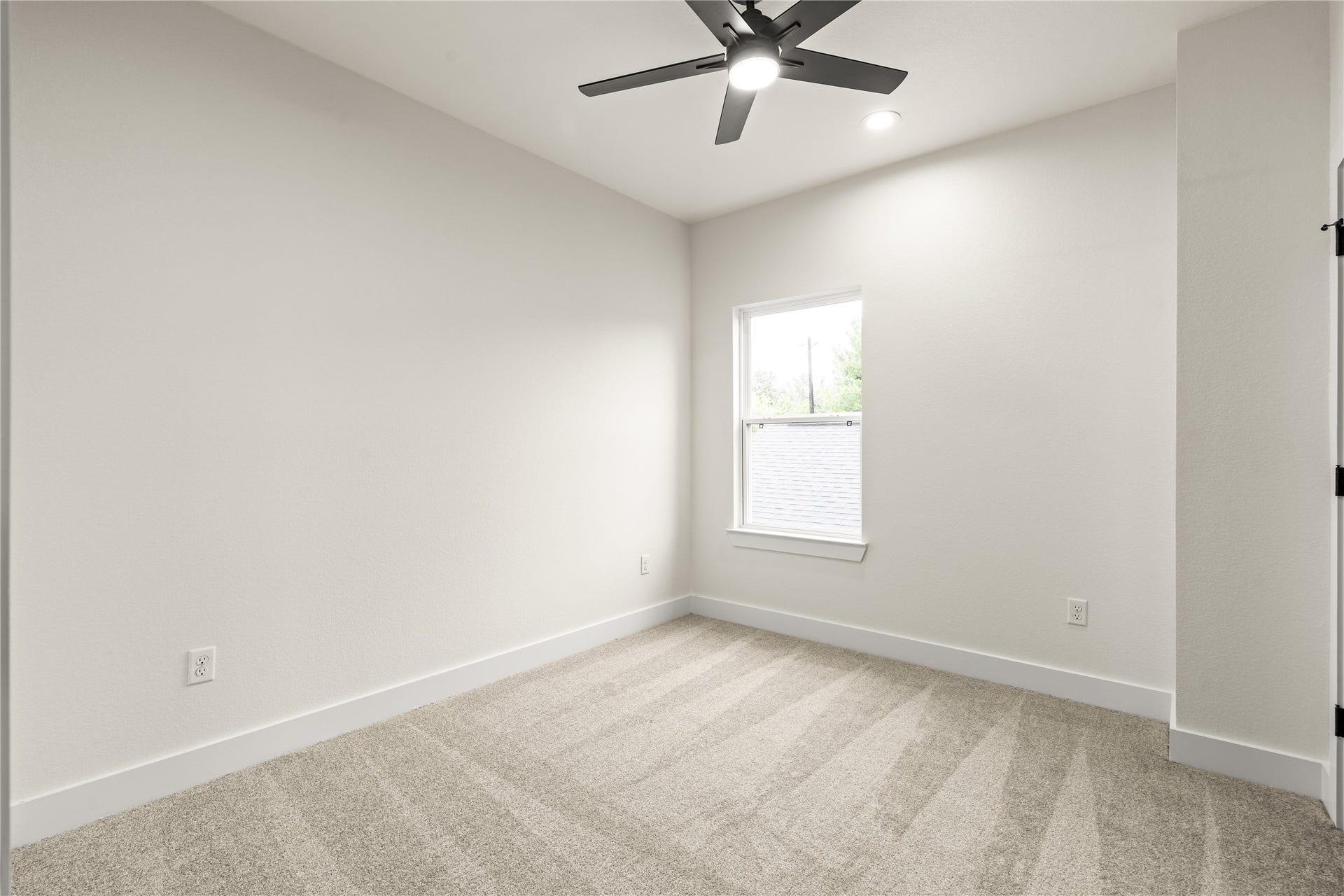 4521 Newberry Street, Houston, TX 77051 Inviting secondary bedroom neutral wall tones paired with soft carpet, matte black ceiling fan, and bright natural light.