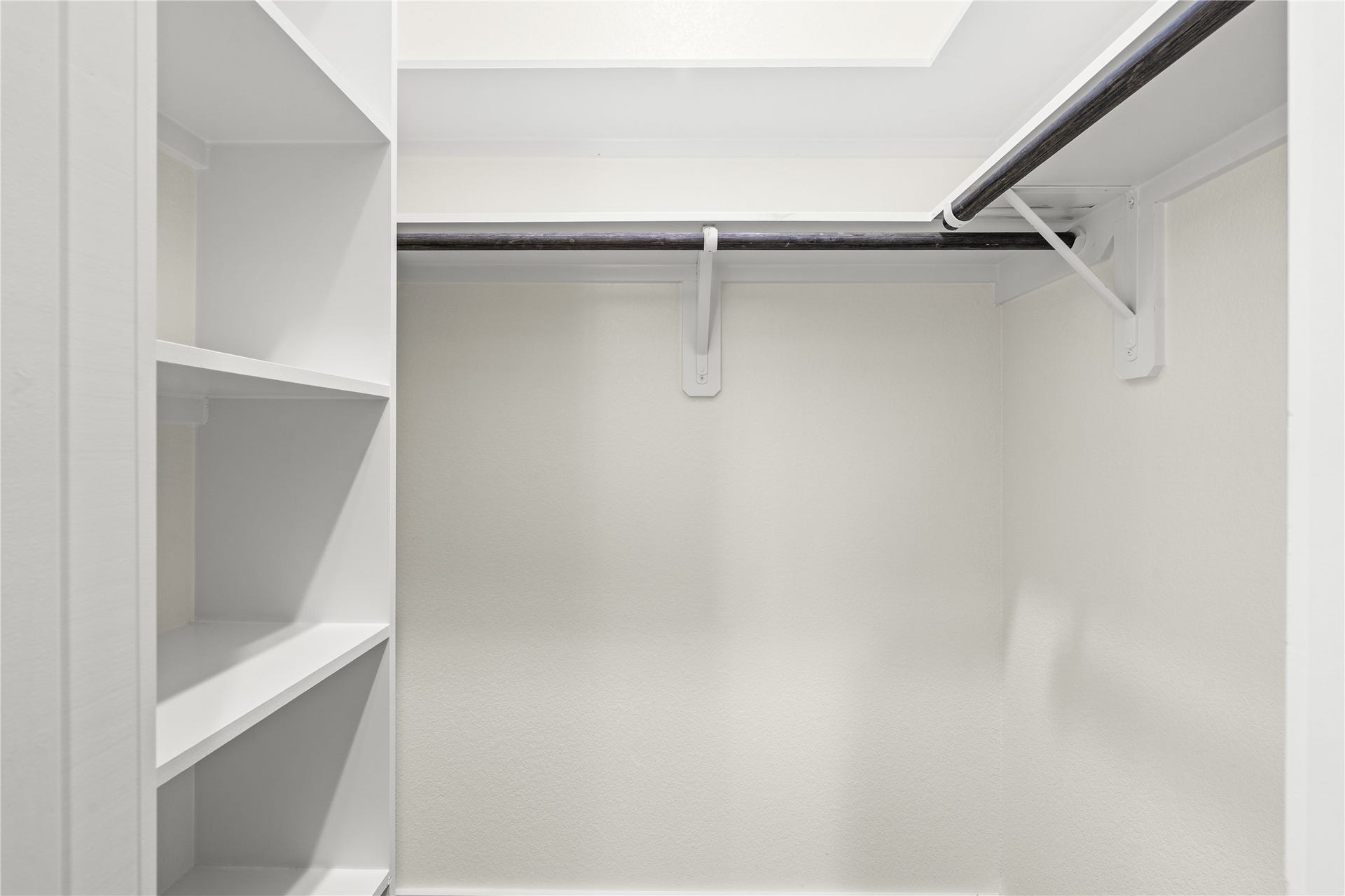 4521 Newberry Street, Houston, TX 77051 Custom walk-in closet open shelving tower and dual hanging rods tailored for optimal wardrobe organization.