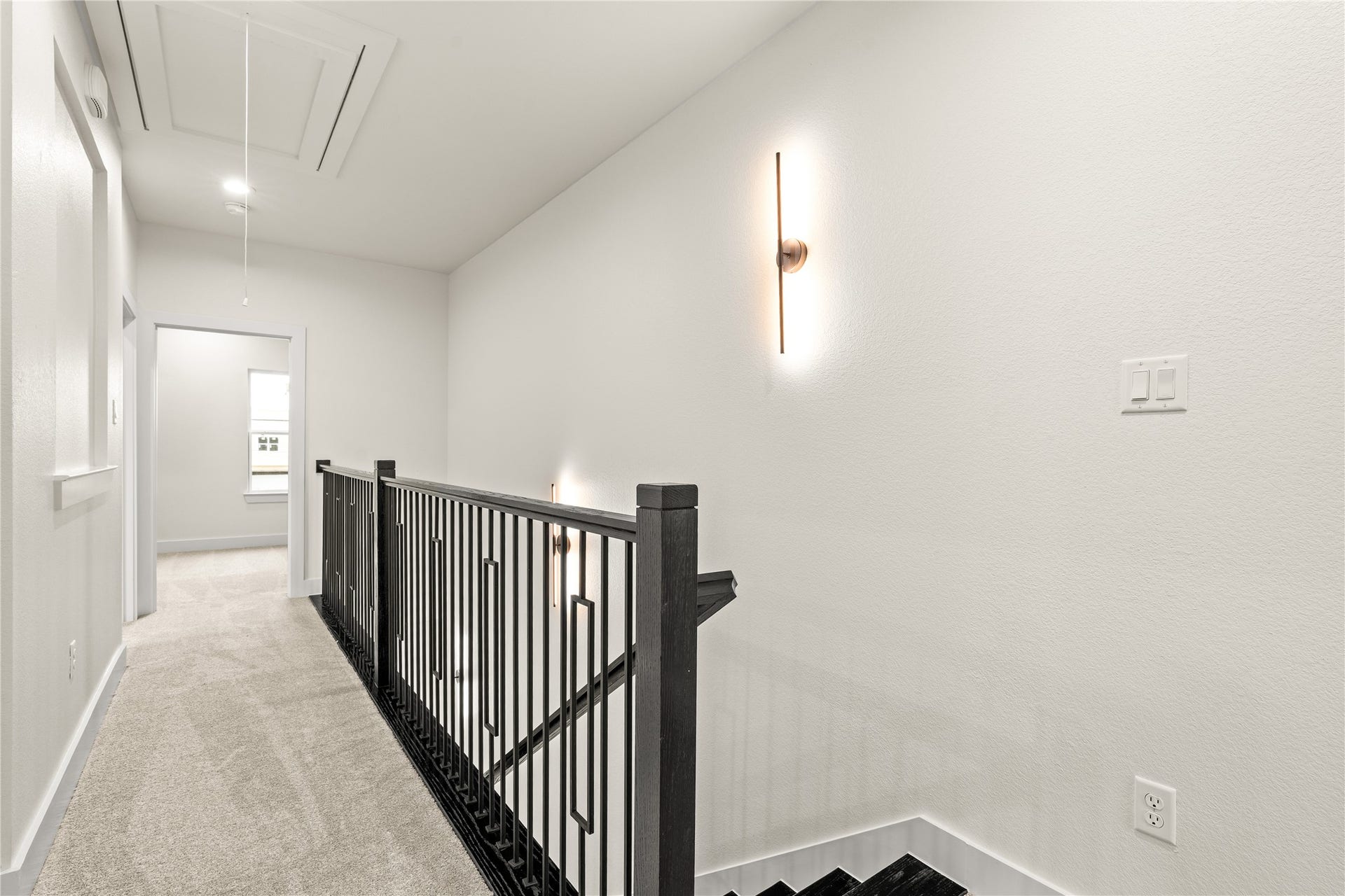 4521 Newberry Street, Houston, TX 77051 Upper level landing plush neutral carpeting, modern vertical sconce lighting, and designer iron railing details.