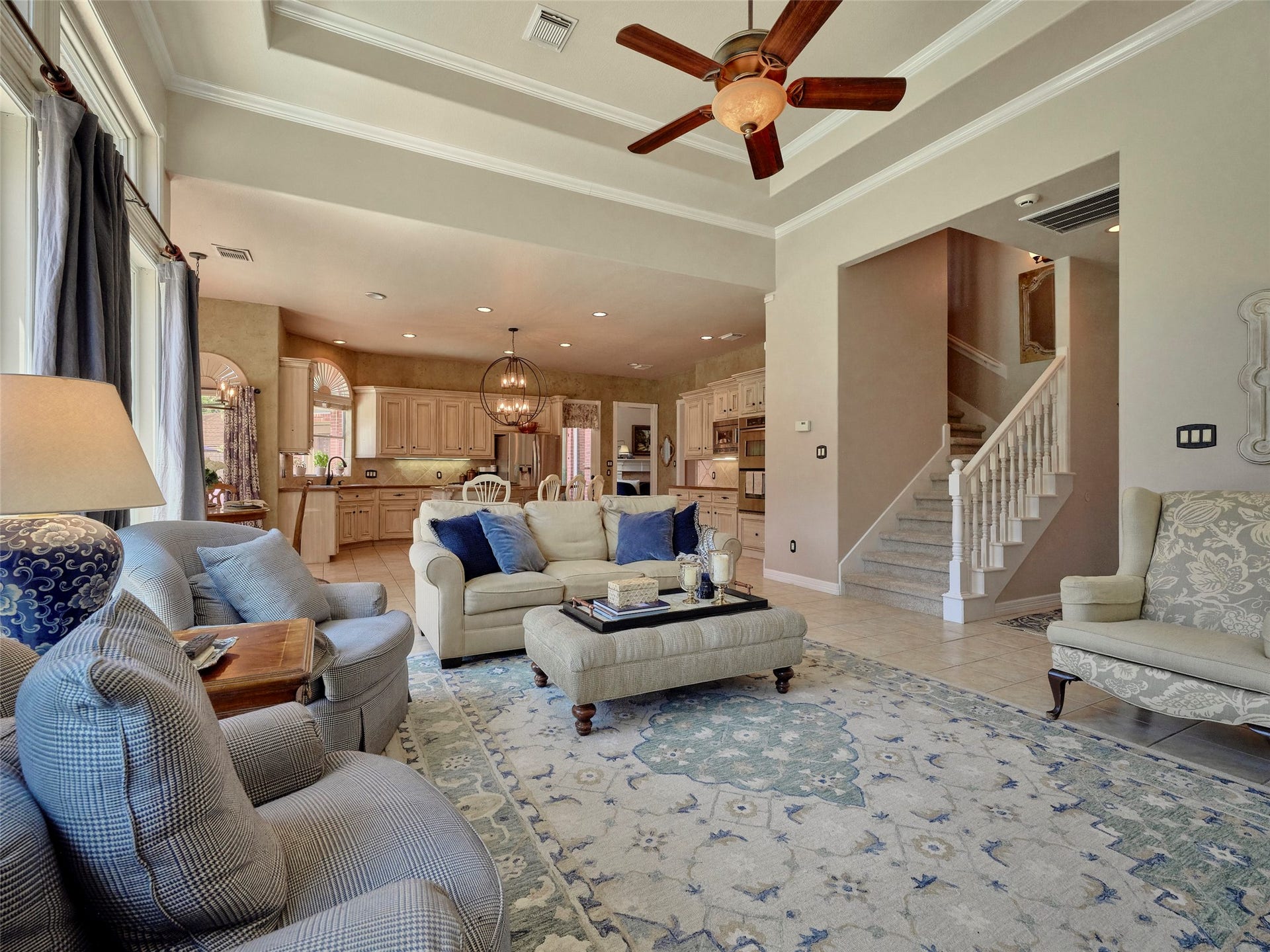 7111 Mohave Hills, Houston, TX 77069 Spacious living area with an open-concept design, featuring elegant tray ceilings, a cozy seating arrangement, and easy access to a bright, modern kitchen.