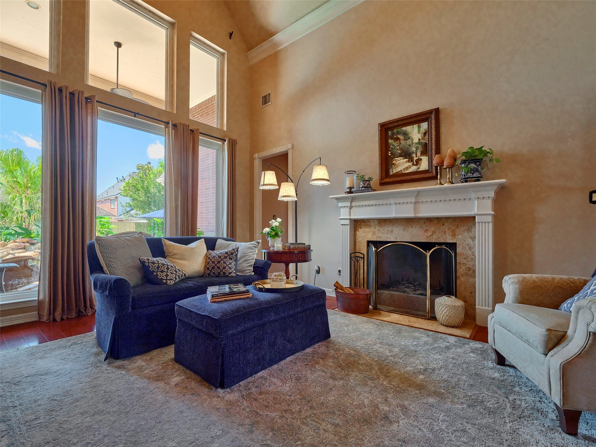 7111 Mohave Hills, Houston, TX 77069 Elegant living room featuring a cozy fireplace, high ceilings, and abundant natural light from expansive windows, creating an inviting atmosphere.