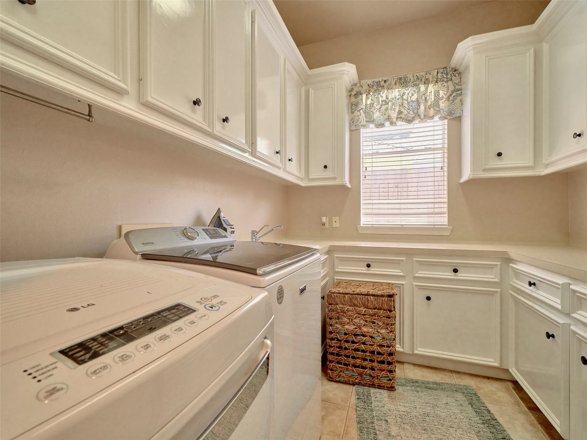 7111 Mohave Hills, Houston, TX 77069 Bright laundry room featuring ample cabinetry, modern appliances, and a convenient window for natural light.