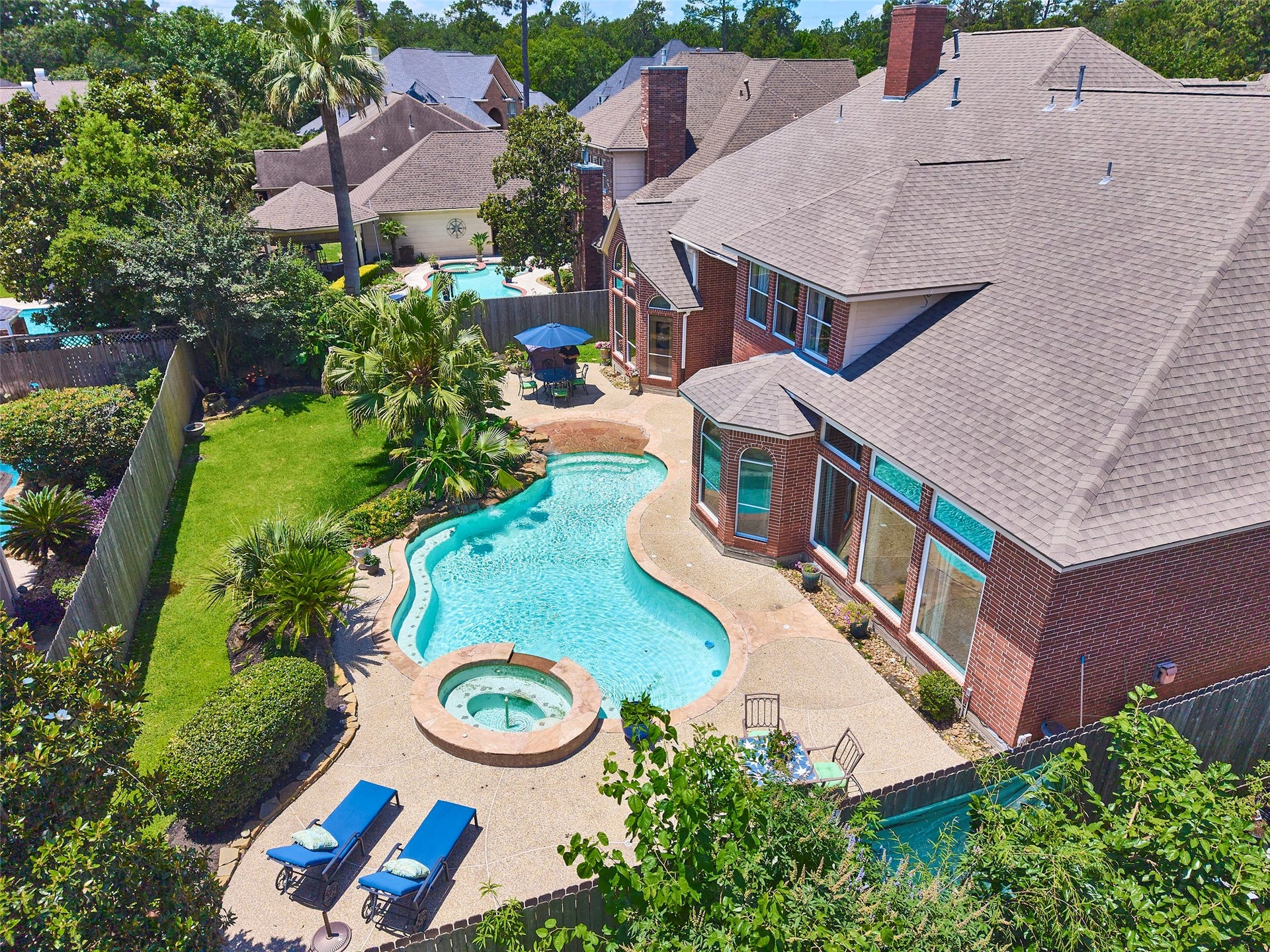 7111 Mohave Hills, Houston, TX 77069 Stunning backyard oasis featuring a sparkling pool with a spa, surrounded by lush landscaping and ample patio space for relaxation.