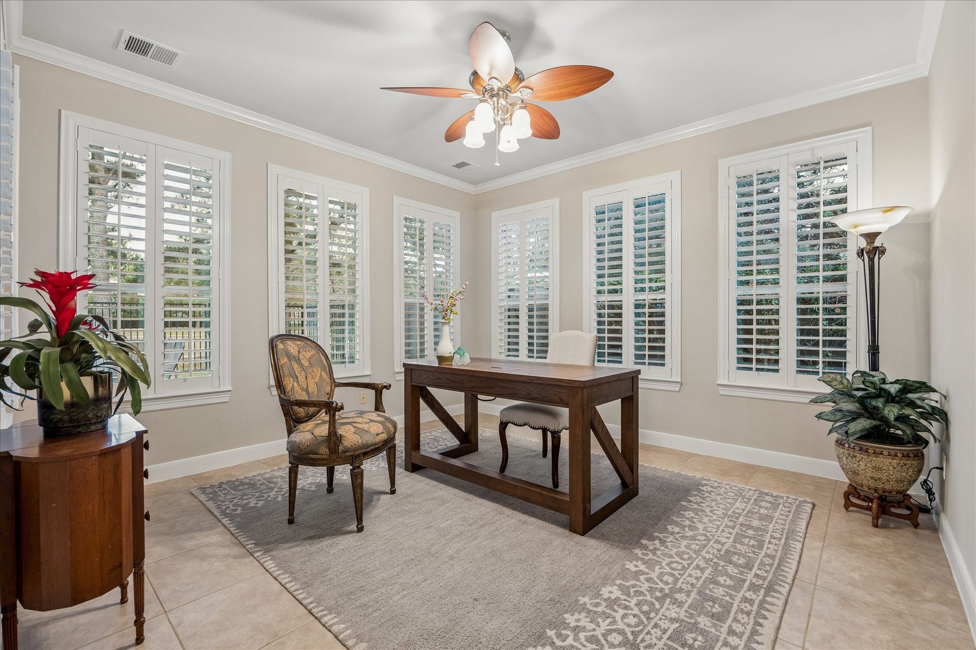 Light-filled and surrounded by two walls of windows, this versatile sunroom is an inviting setting for a home office, reading space, game room, or whatever best suits your lifestyle.