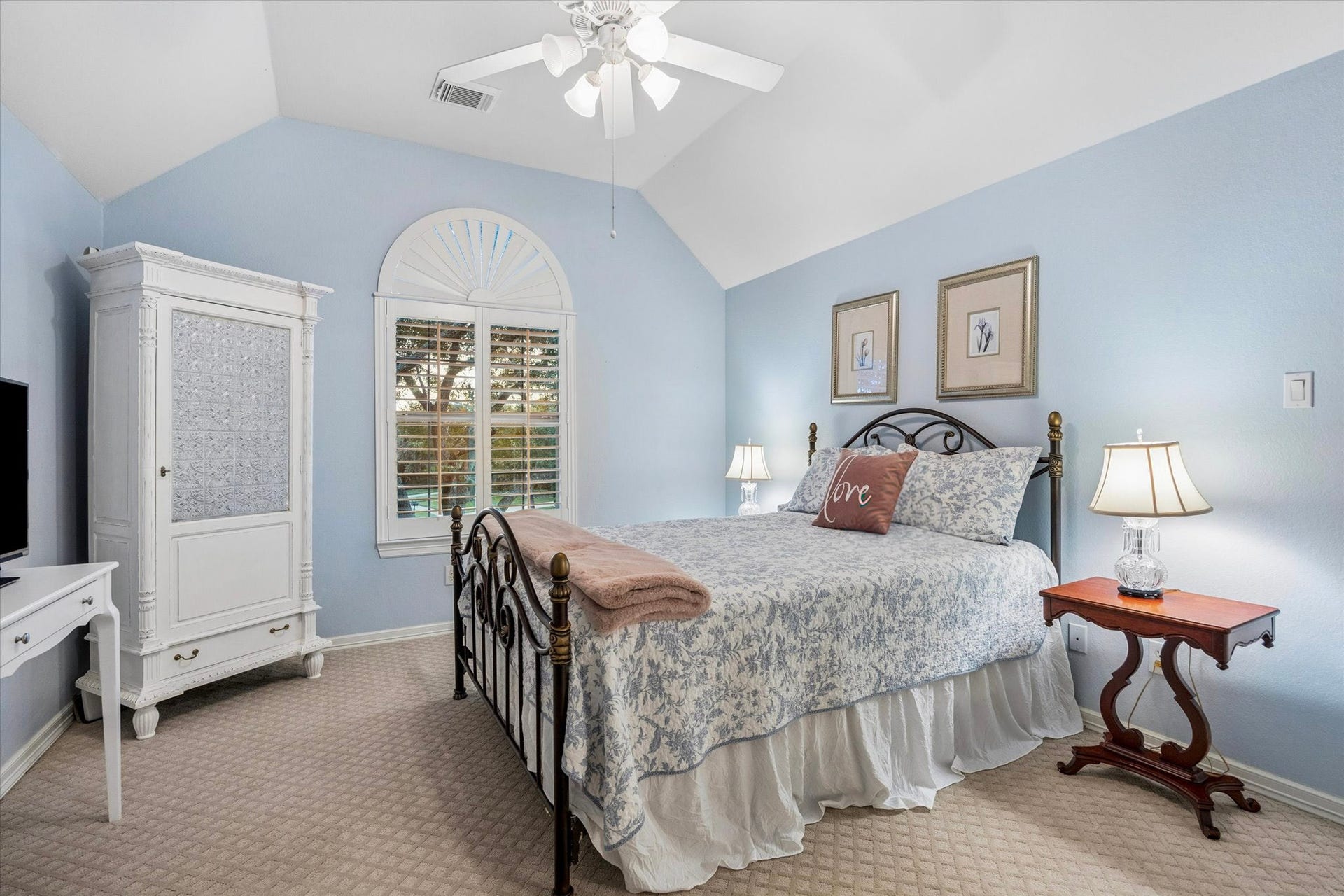 This front facing bedroom has vaulted ceilings with fan, closet, and personal vanity.