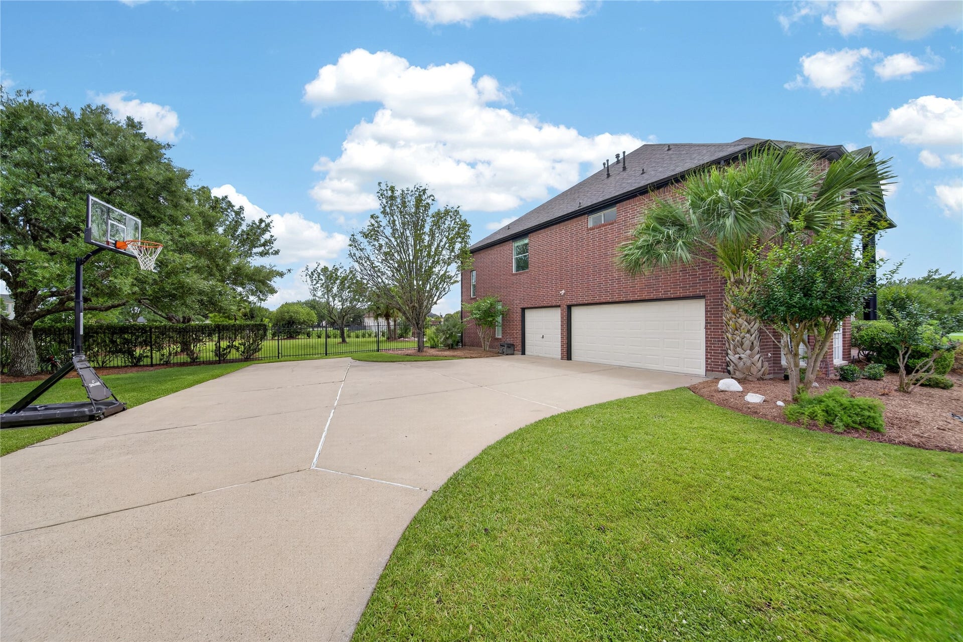 8826 Crown Jewel Drive, Richmond, TX 77469 The expansive driveway leads to a three-car garage and showcases beautifully landscaped surroundings.