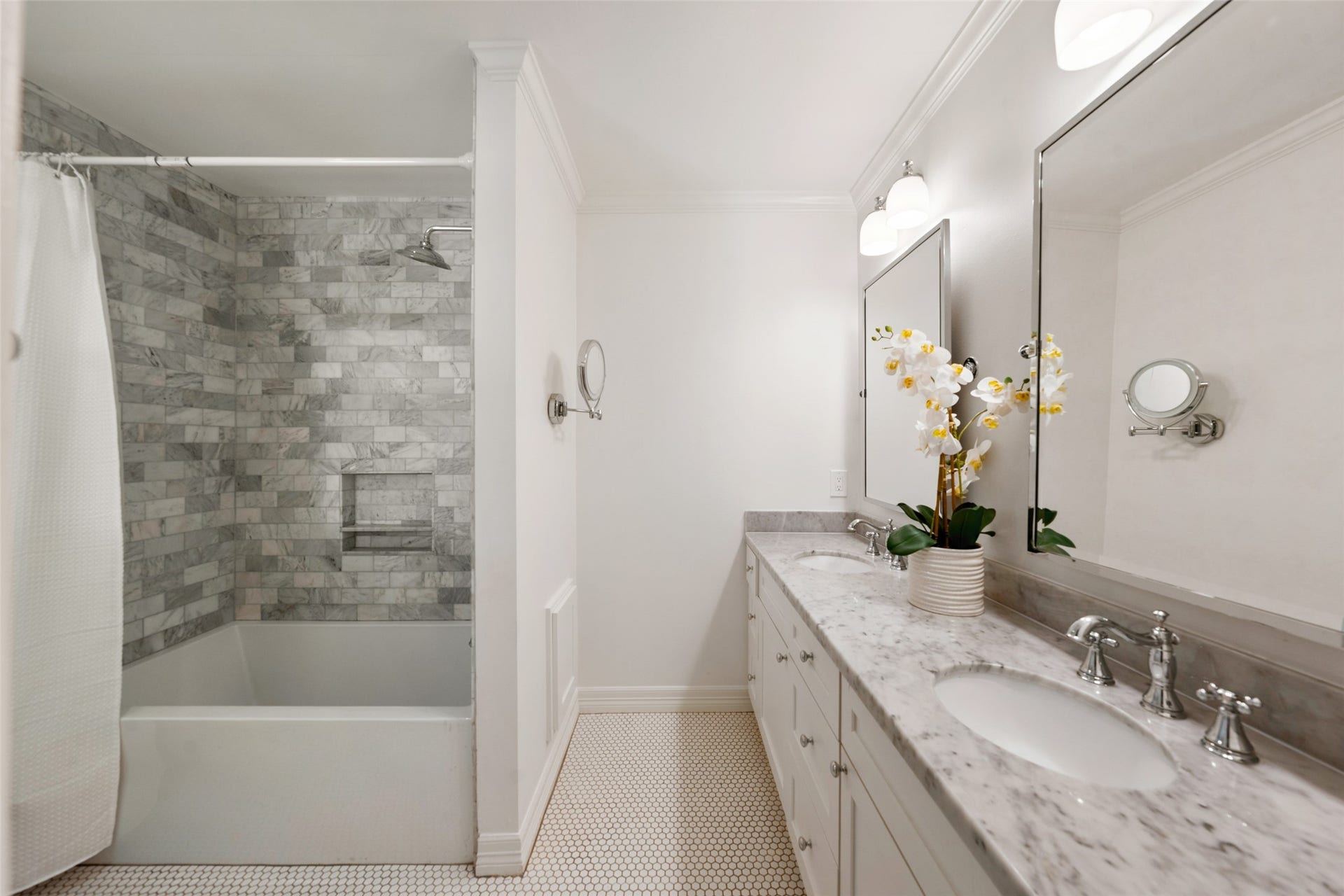 1343 Del Norte Street, Houston, TX 77018 Updated primary bath features a dual-sink vanity with stone countertops, generous storage and a tub/shower surrounded by classic marble tile.