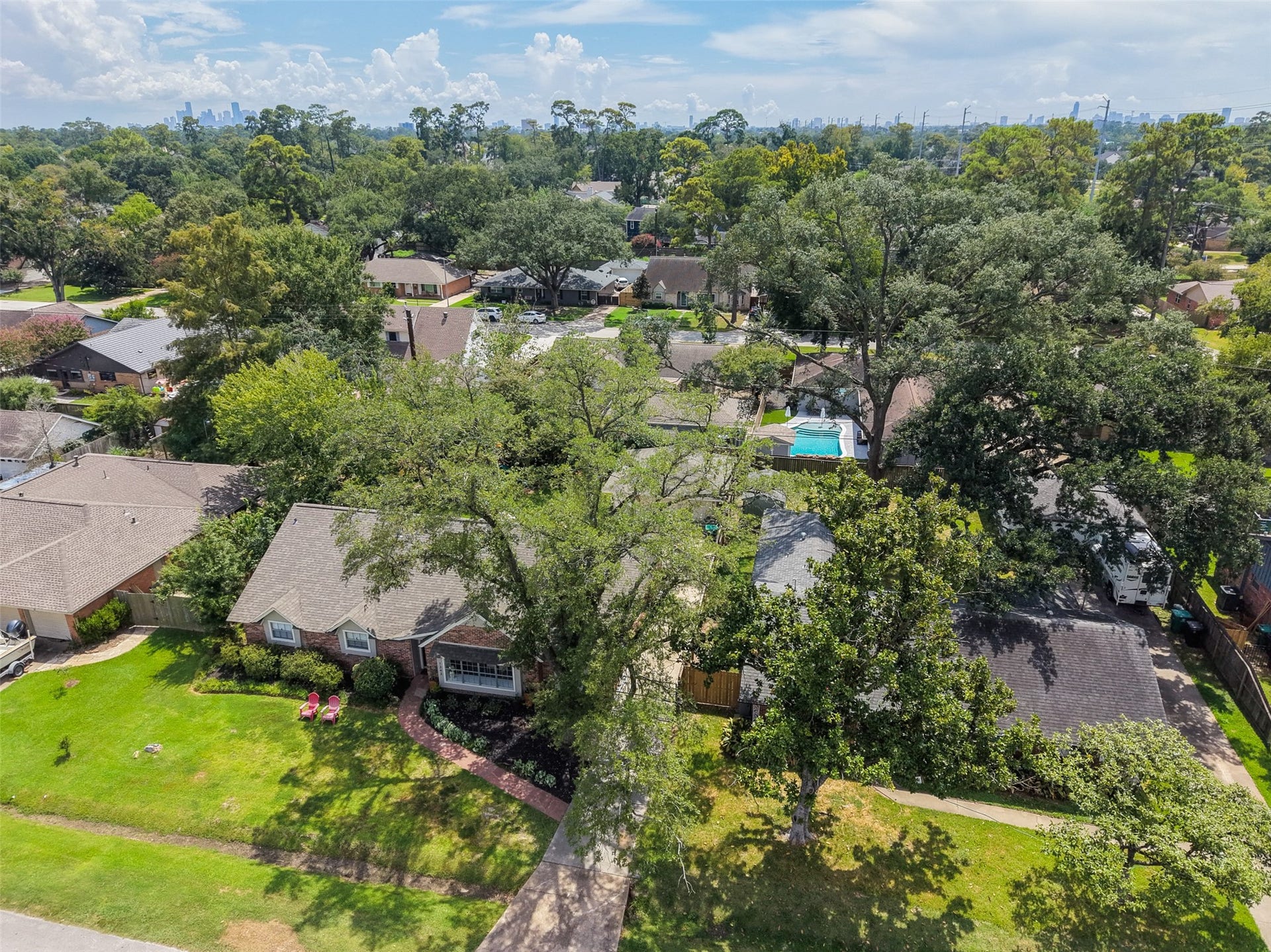 1343 Del Norte Street, Houston, TX 77018 Aerial view showcases the homes tree-lined neighborhood setting with the Houston skyline visible in the distance.