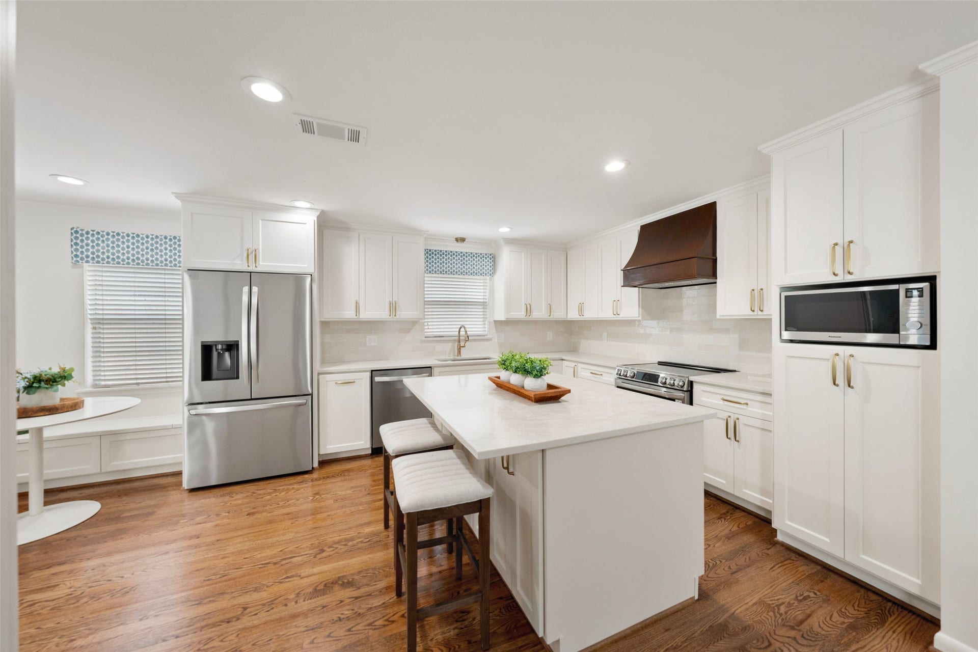 1343 Del Norte Street, Houston, TX 77018 Bright, updated kitchen features abundant cabinetry, a large center island with seating, stainless steel appliances, hardwood floors and a charming breakfast nook with built-in bench seating.