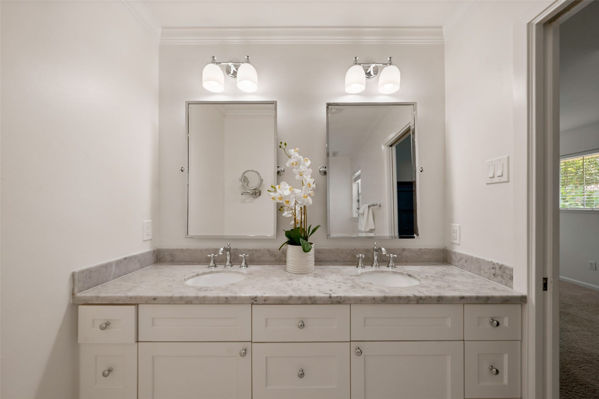1343 Del Norte Street, Houston, TX 77018 Closer view of the dual-sink vanity featuring marble countertops, plentiful cabinet storage and separate mirrors with updated lighting.