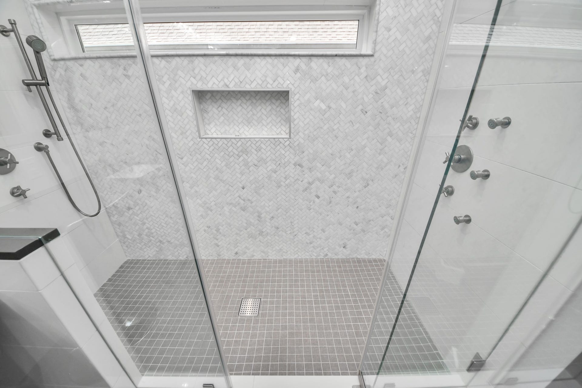 Luxurious custom shower in the primary bedroom featuring body sprayers, wands and custom set temperature controls on both sides for the perfect shower, every time!