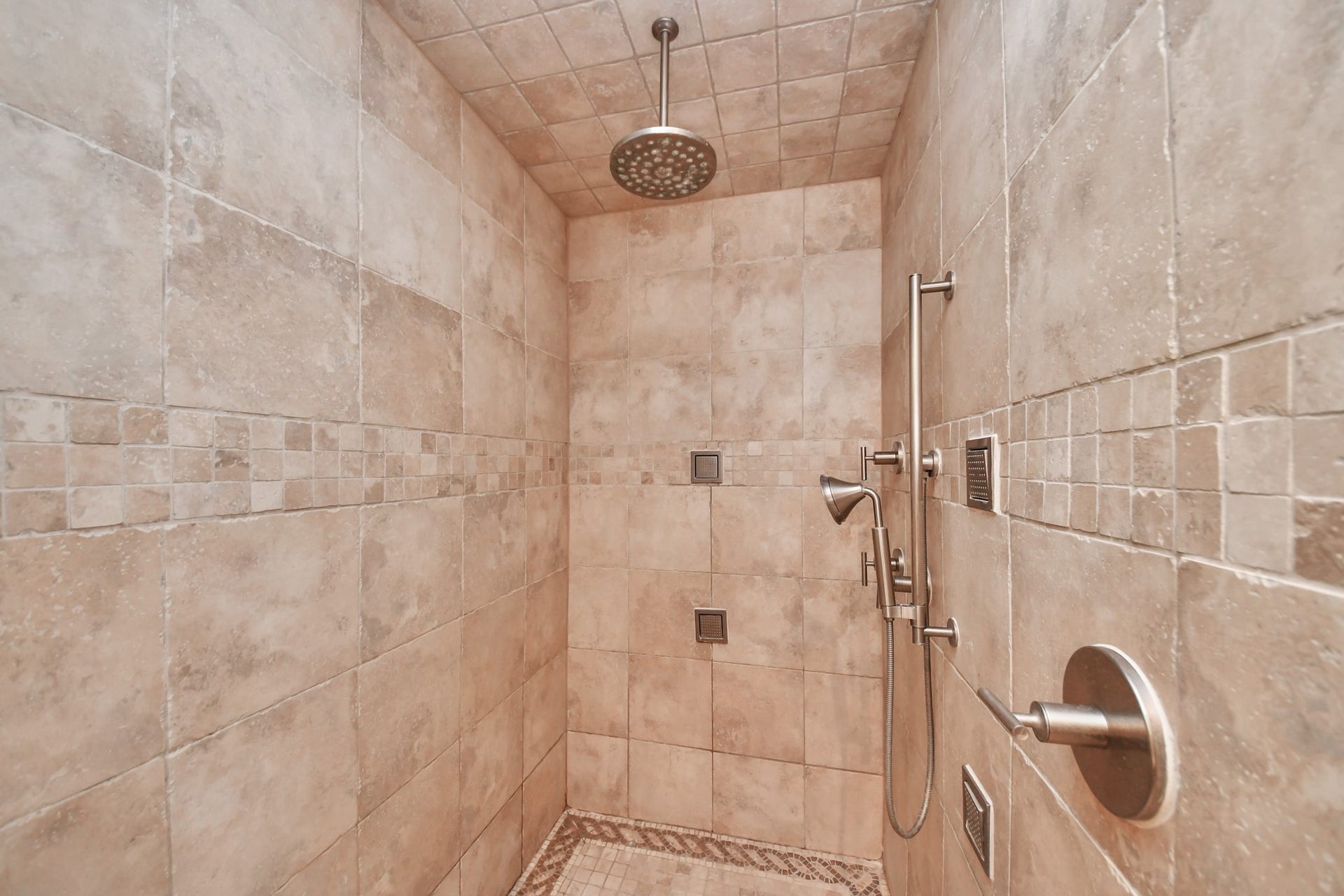 722 Chevy Chase Circle, Sugar Land, TX 77478 Walk-in shower features floor-to-ceiling tile, a rainfall showerhead, handheld sprayer and body sprays.