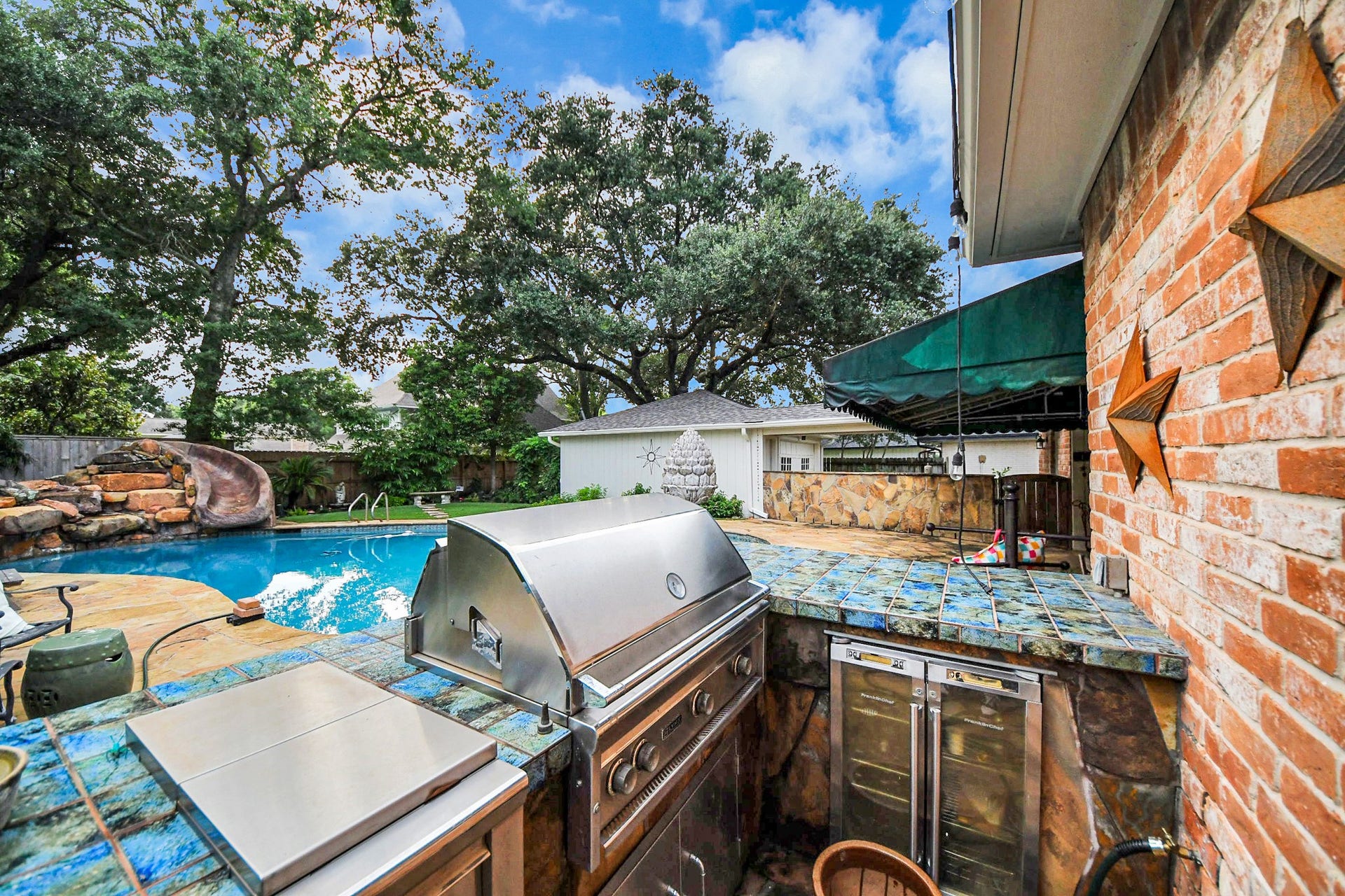 722 Chevy Chase Circle, Sugar Land, TX 77478 The outdoor kitchen features a built-in grill, tile surround and generous prep space, perfectly positioned for easy poolside entertaining.